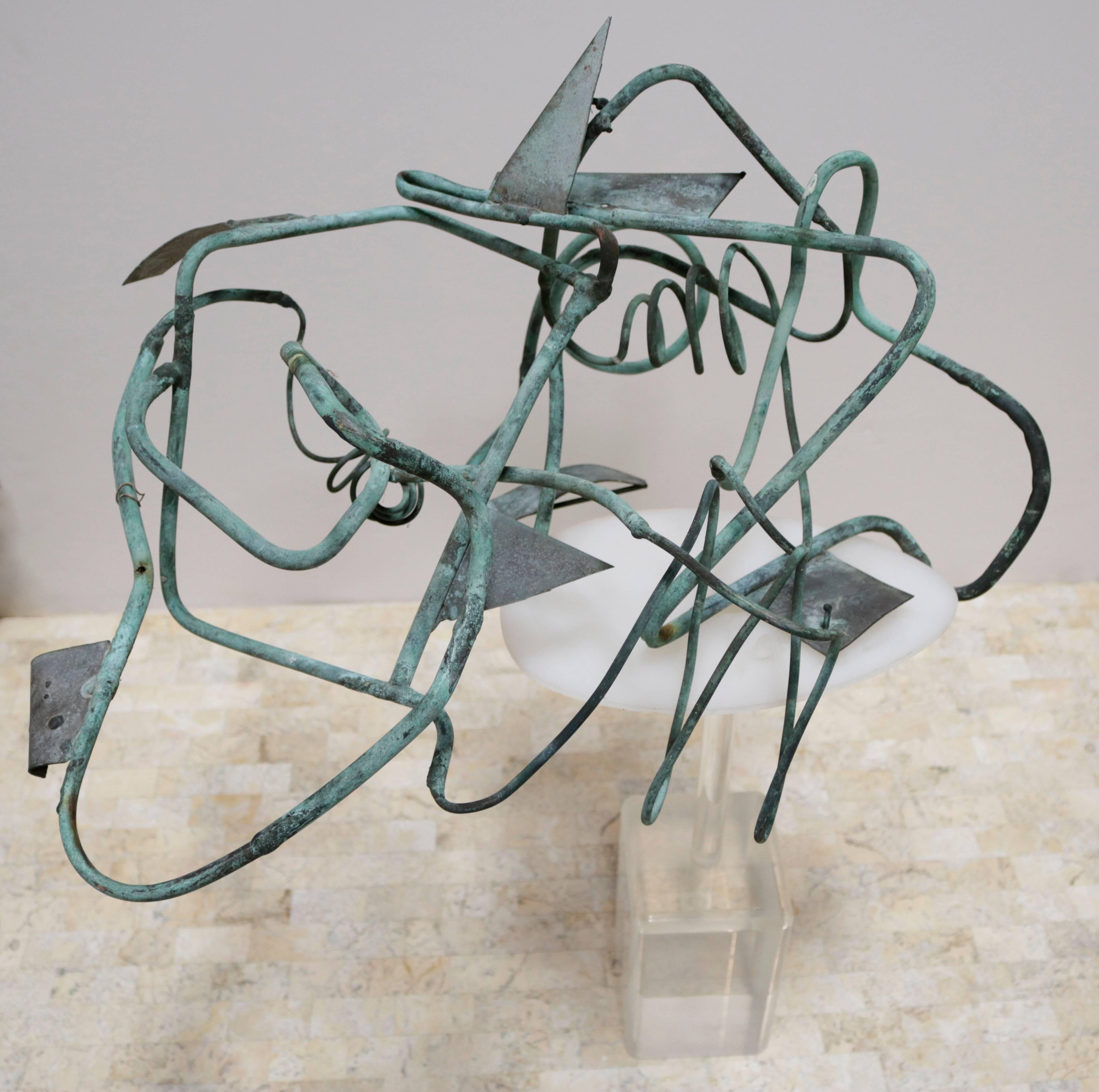 Abstract patinated bronze sculpture on a Lucite base. Sculpture attaches to base by way of one small piece of the bronze which acts as a kind of hook to latch onto the Lucite. Unknown artist.