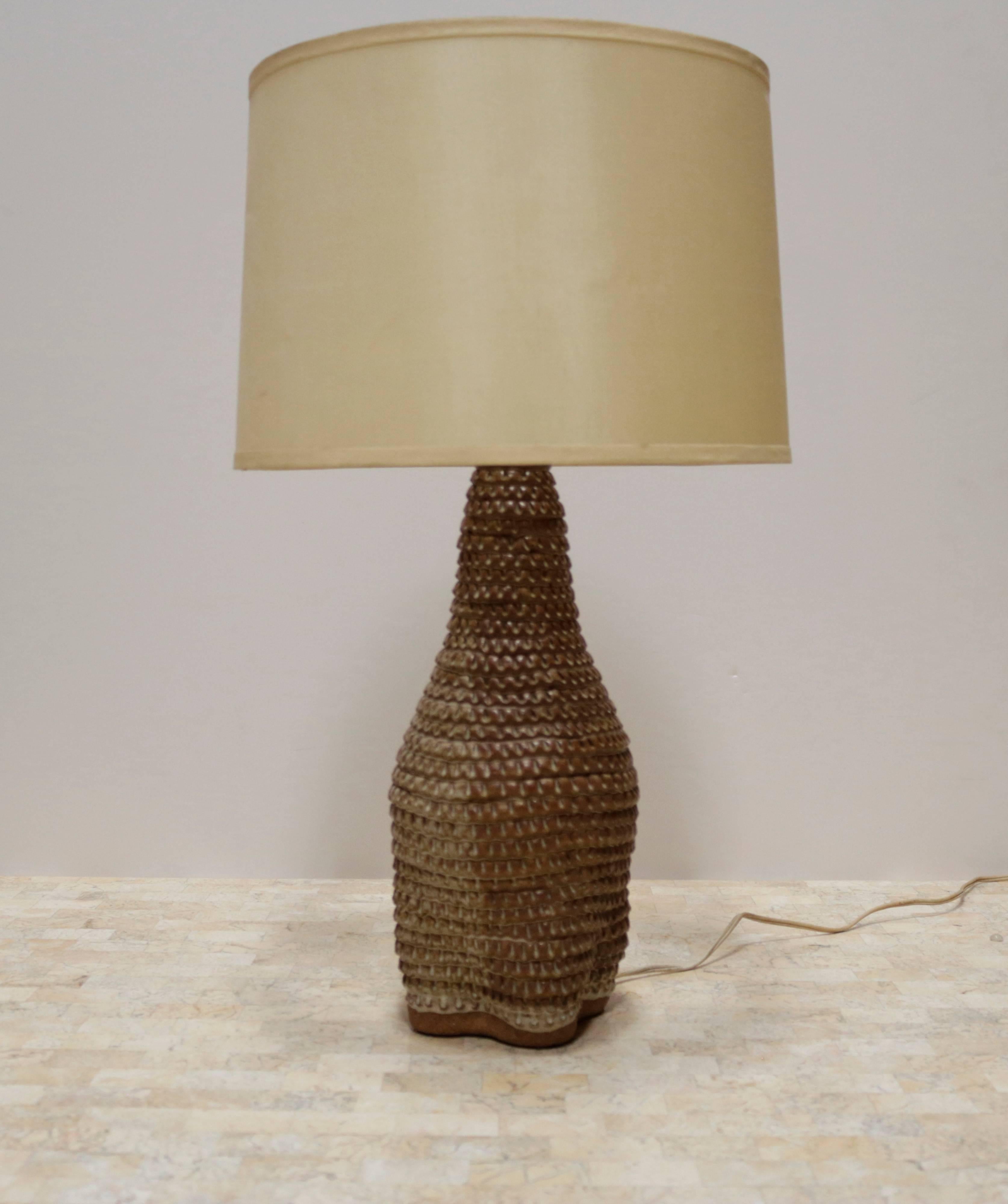 Tan ceramic California table lamp. Highly textured surface has a corrugated effect. Comes with original shade. Signed on the bottom 