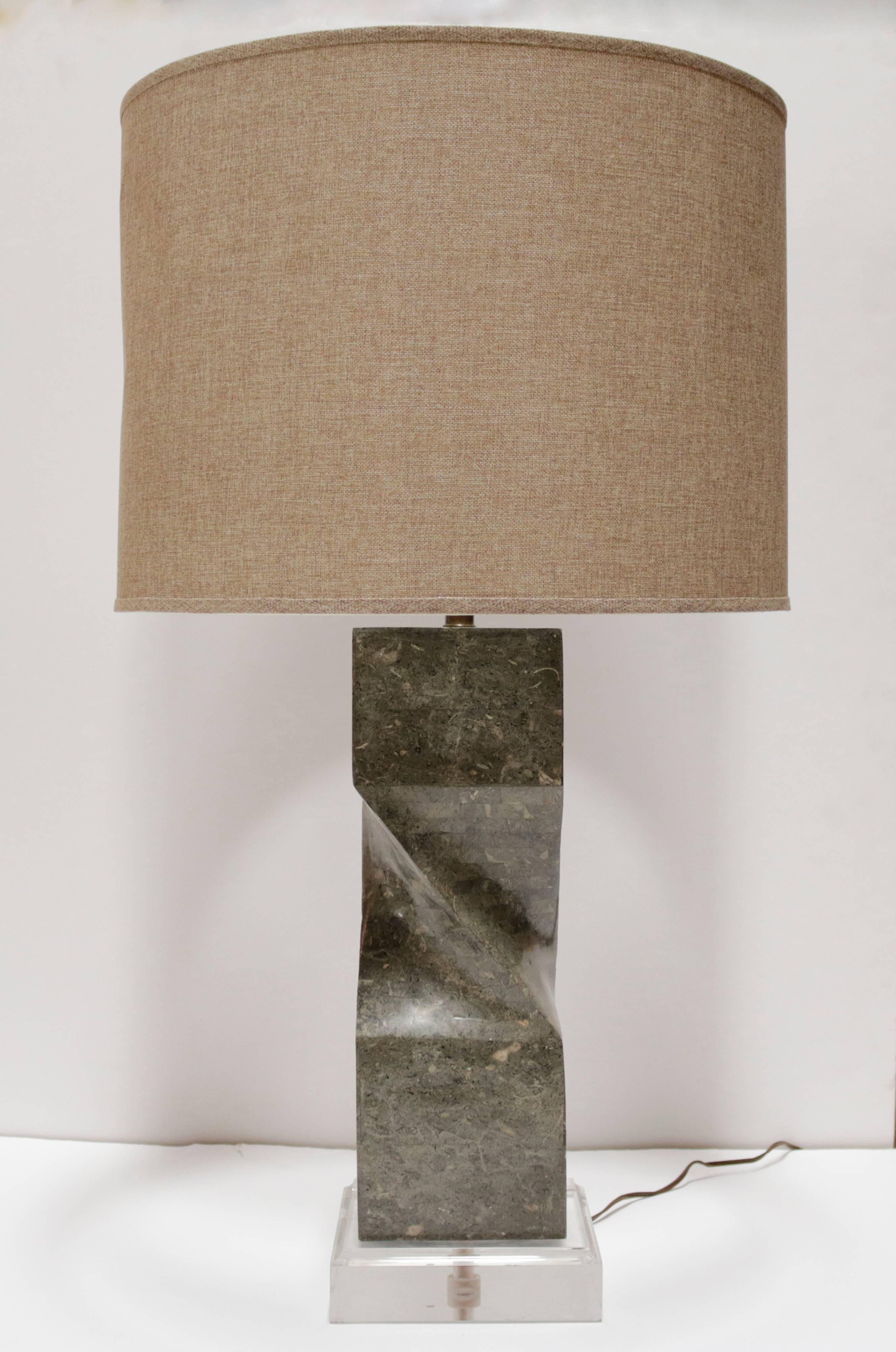Large table lamp on a Lucite base with beige linen shade. Lamp is made of tessellated sage green colored marble pieces, with an interesting twist detail at the center. Measures 21