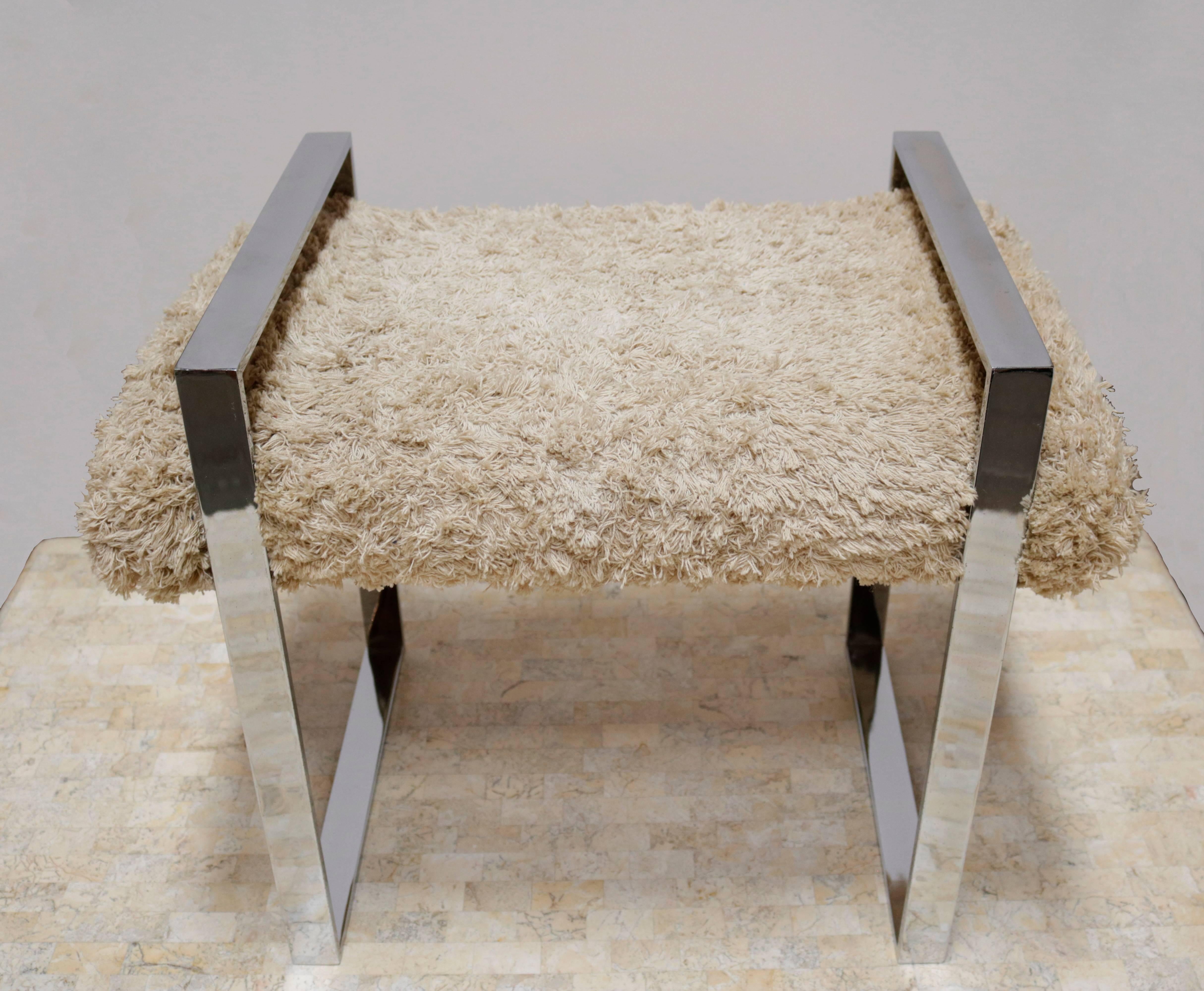 The frame of this bench is made of chromed steel and the upholstery is of cotton fabric looking like sheep fur.