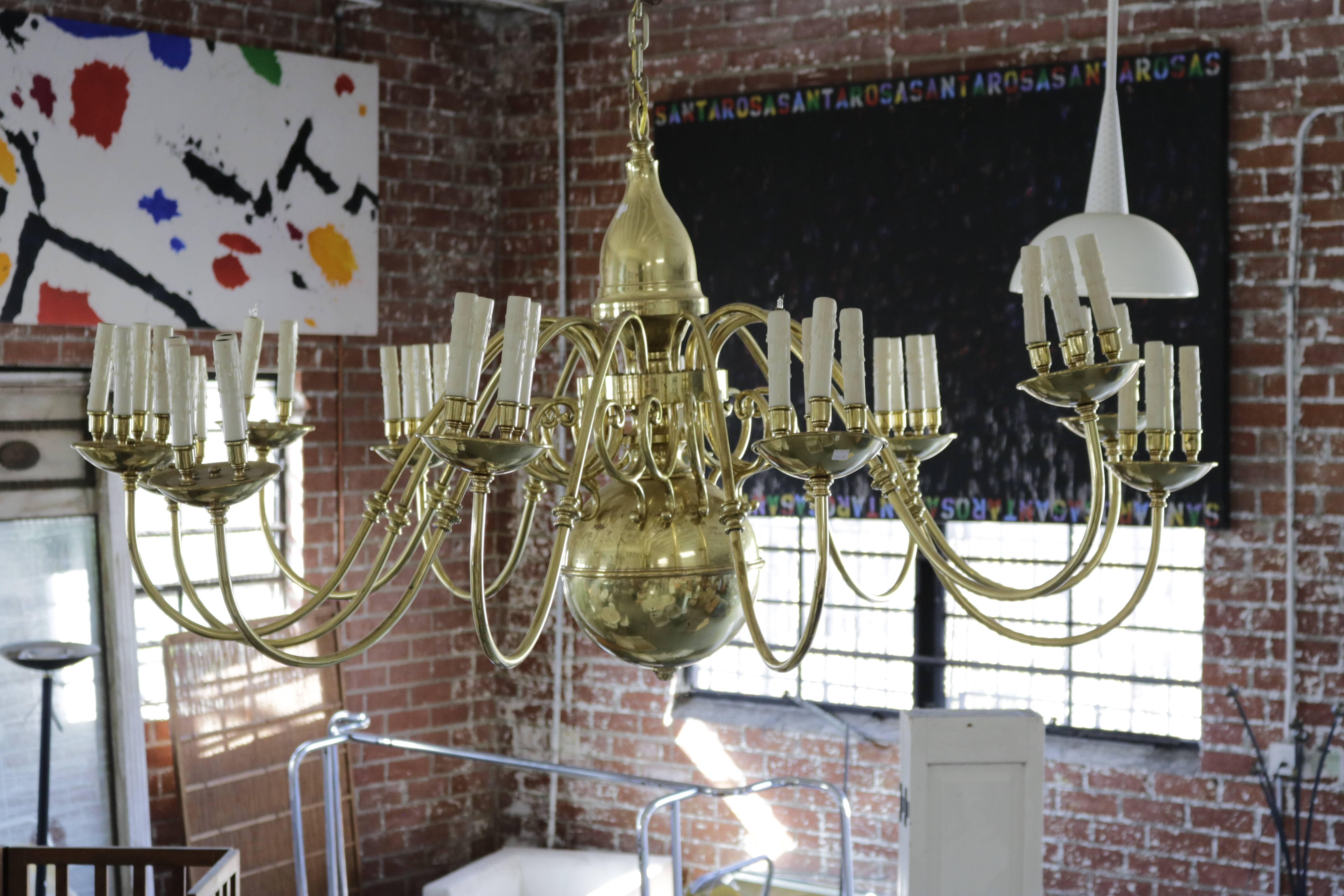 This Dutch style brass chandelier features 12 arms, each one holding four faux drip wax candles.