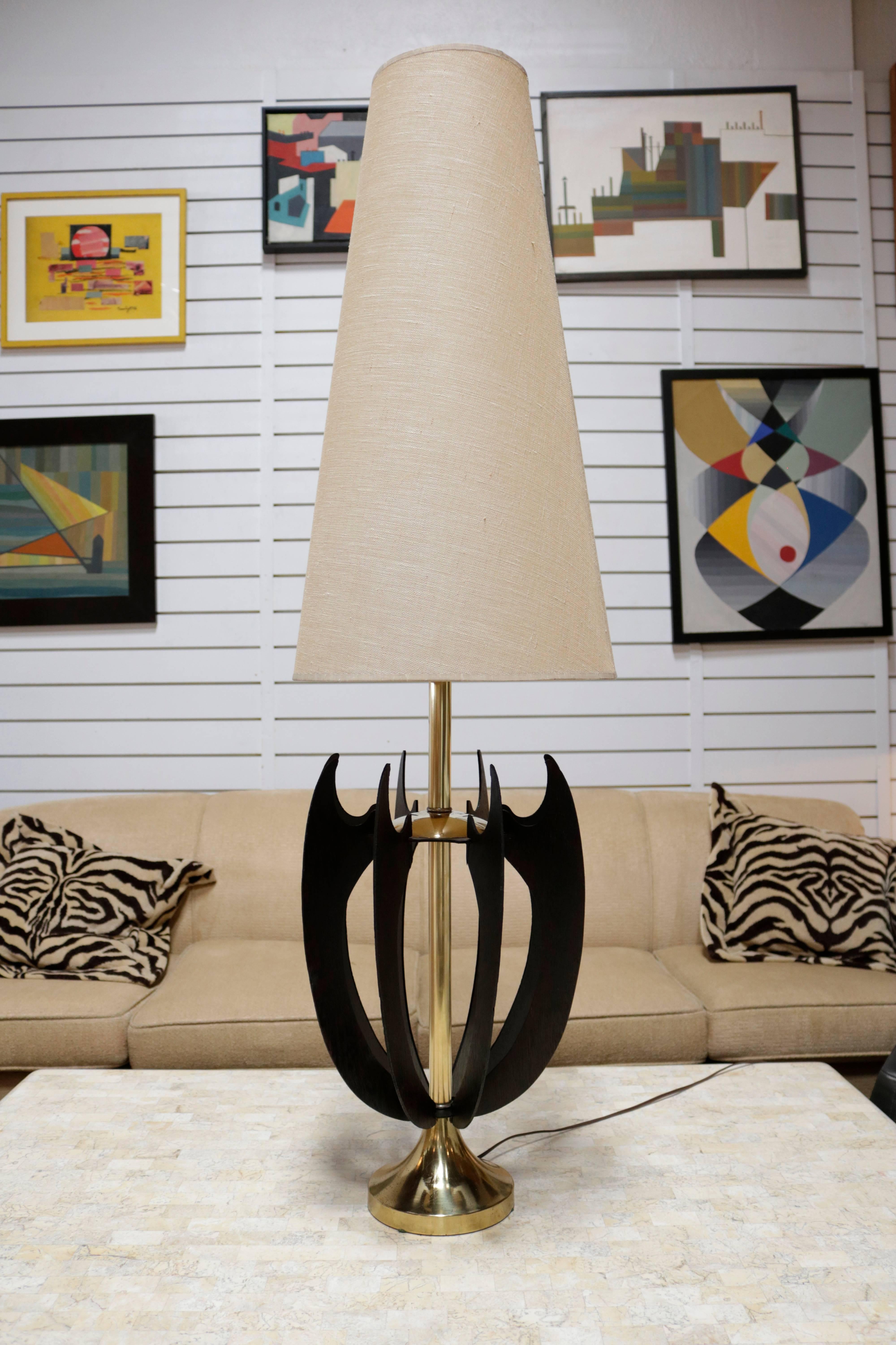 These Danish midcentury lamps have six sculptural strips of wood that join at the bottom base and curve up in a wider design. A brass base and shaft hold up the wood parts and shade. Newly stained black. Measures 50" tall as pictured or