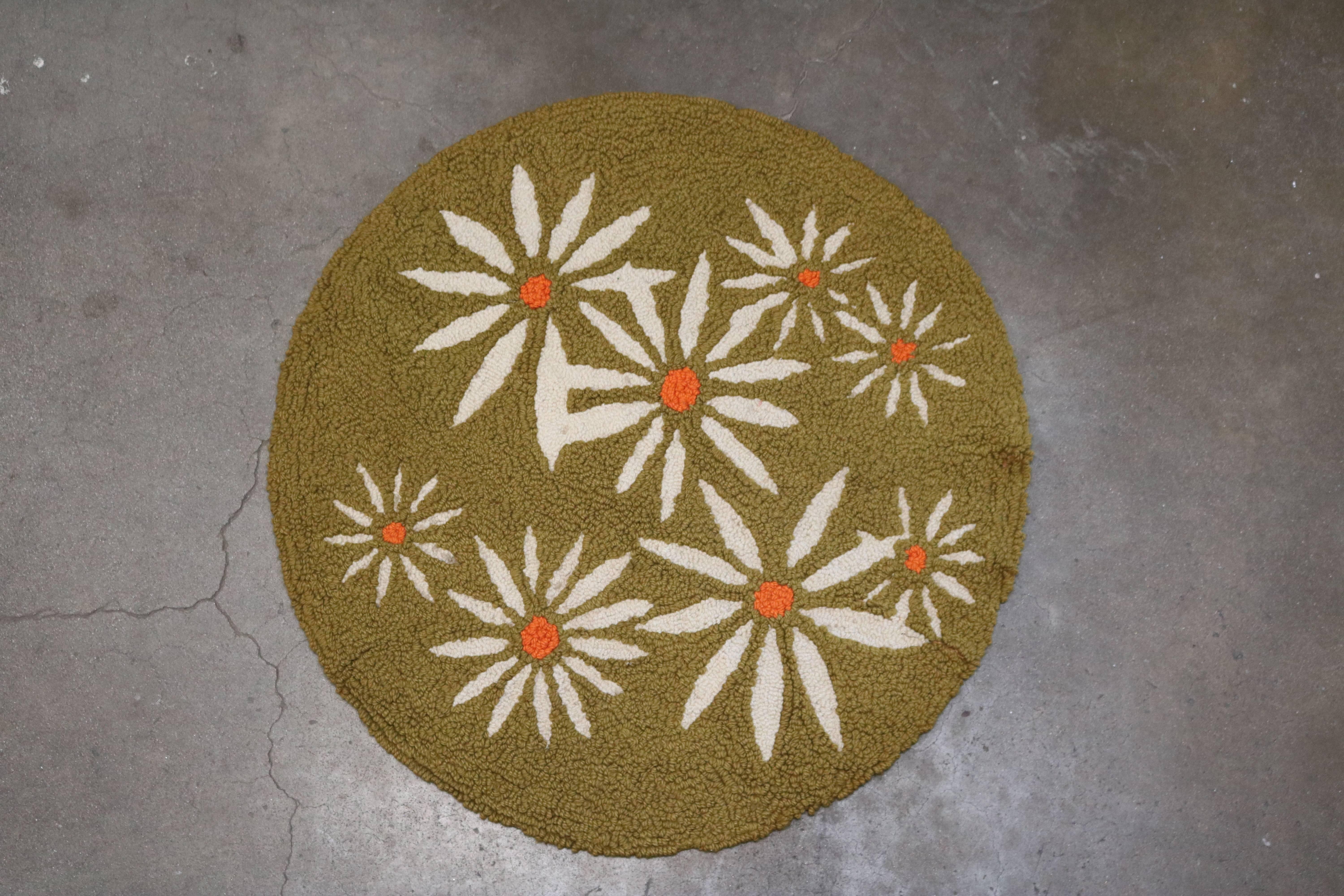 Round rug measures 3 ft. in diameter and is in an avocado green shade with white daisy design.
We have had a new backing put on the rug recently.