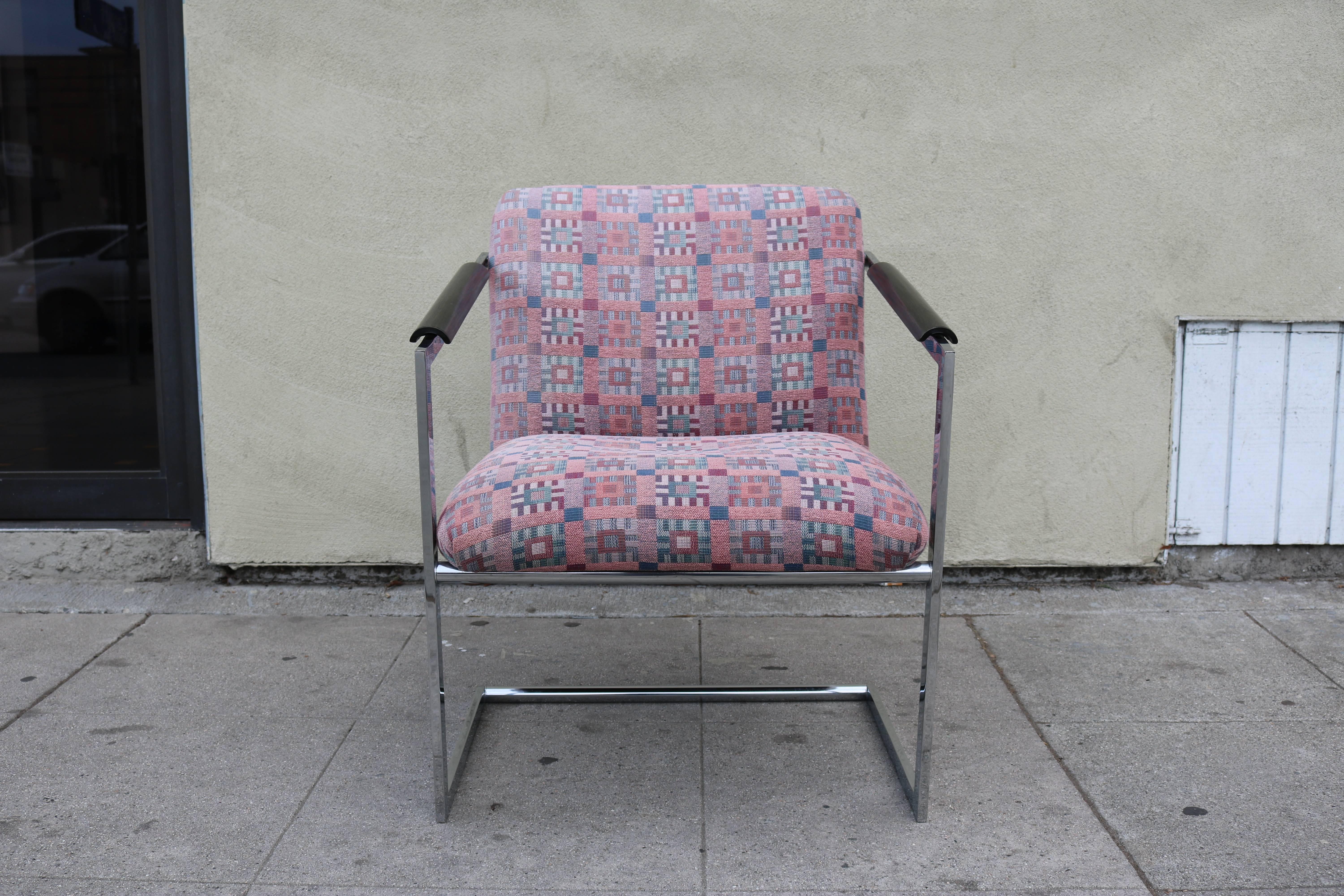 Pair of slopped arm flat barre chrome chair upholstered in Jack  Larsen fabric.
The arms are protected with black lacquer wood rest.