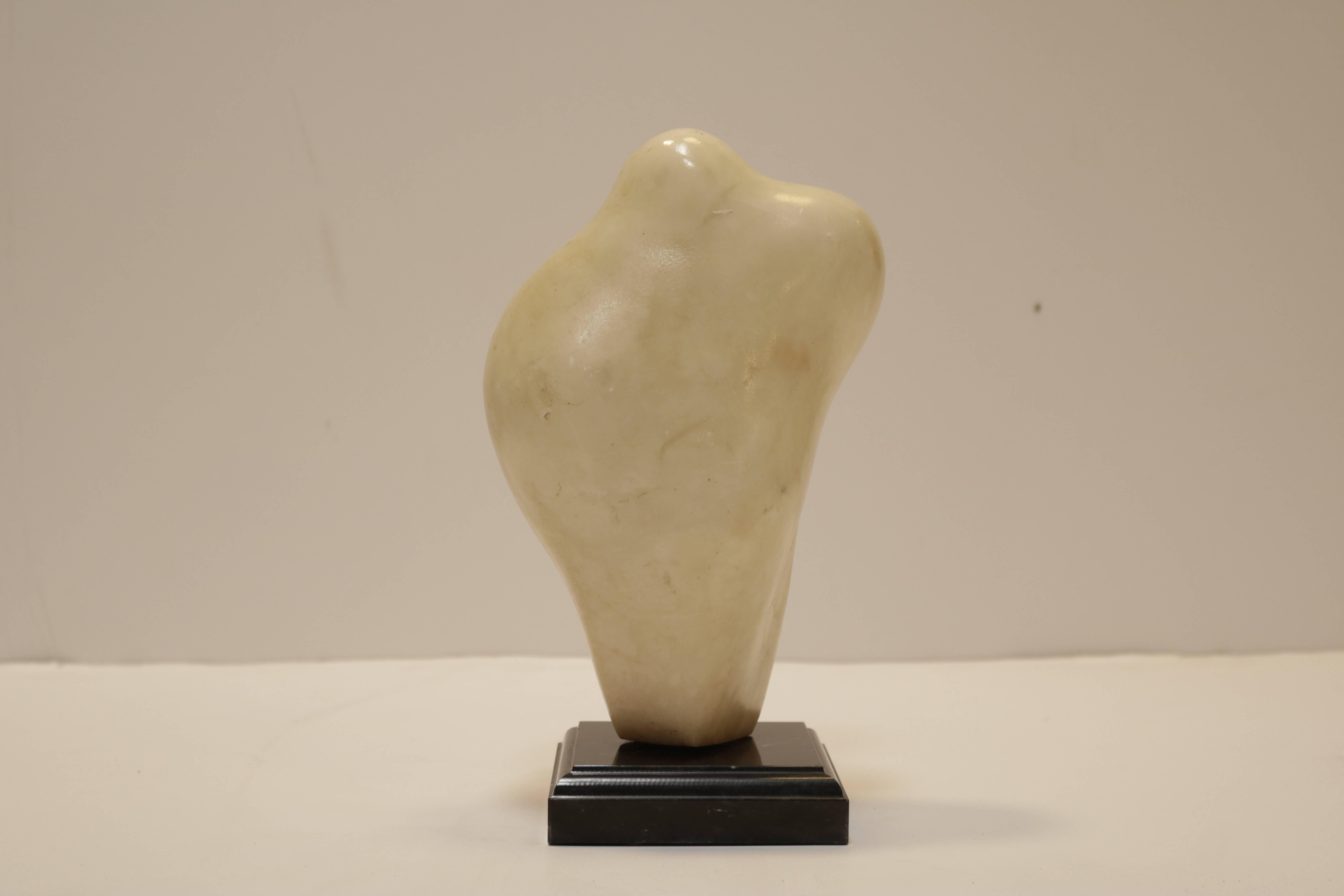 Small carved figurative white marble sculpture on a black marble base. Istvan Toth was a Hungarian artist who lived and worked in the Hollywood Hills from the 1960s through the 1990s.
