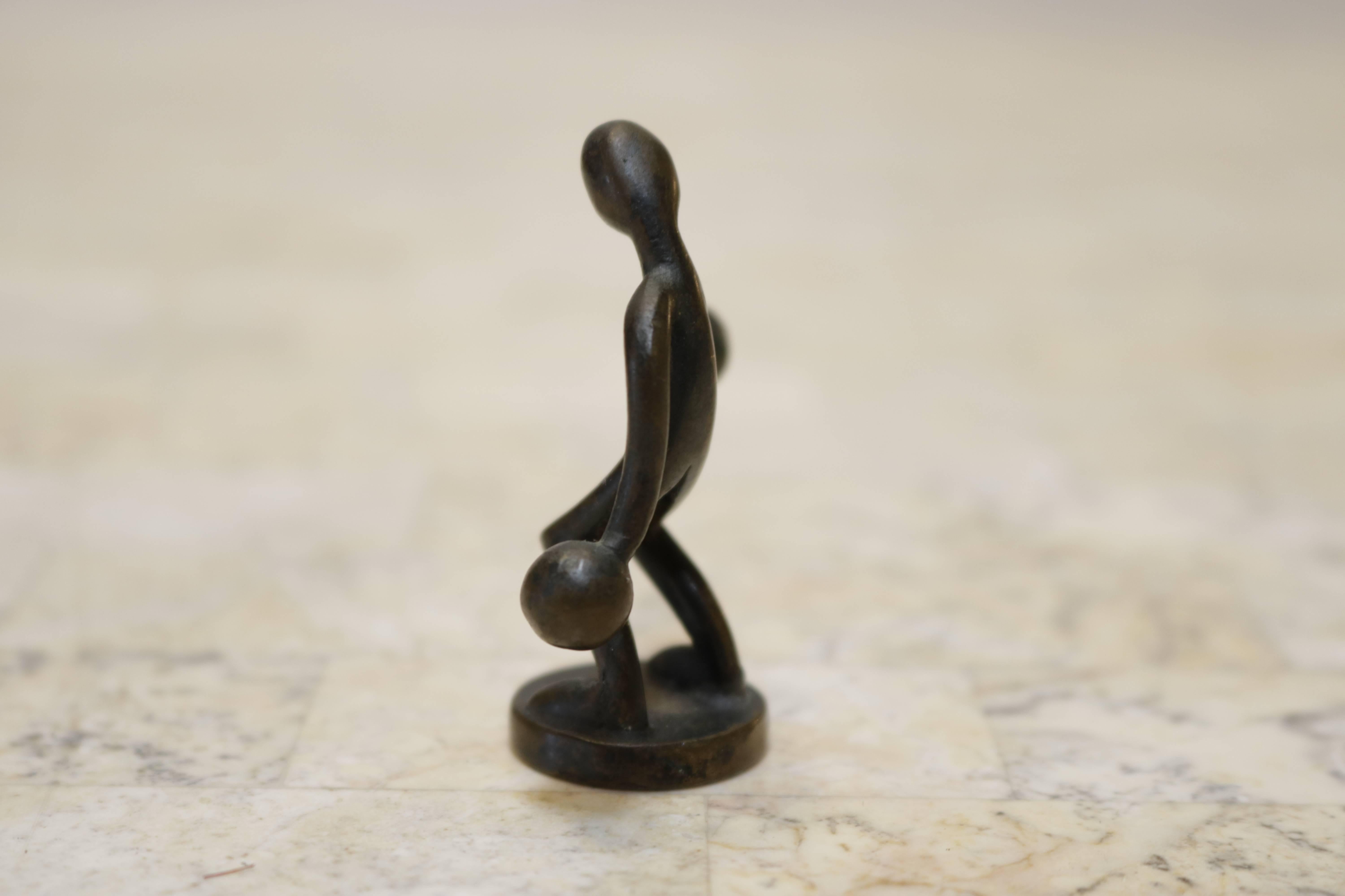 Unusual small bronze figurine of a boxer on a round base. Makes a charming desk accessory or paperweight. No signature.