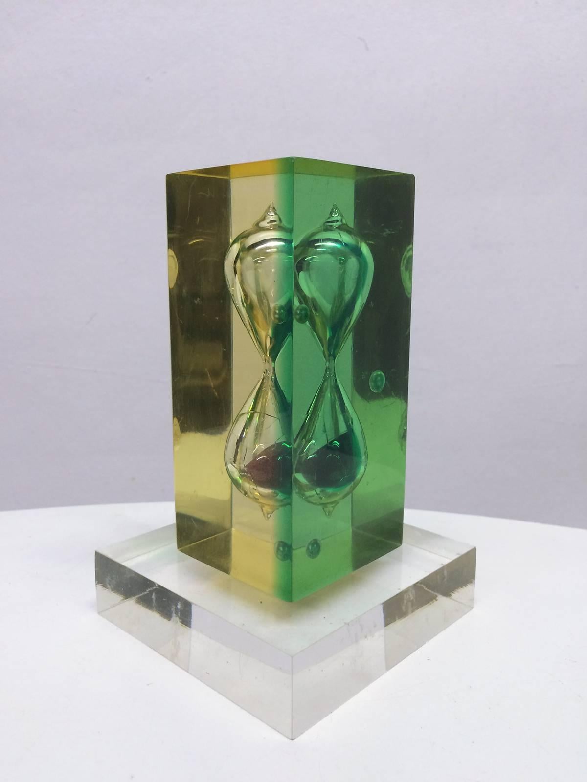 This lucite hourglass looking bubbles within yellow and green tinted lucite.  The object sits on a clear lucite base.  Incredible visual variation from every angle.
.