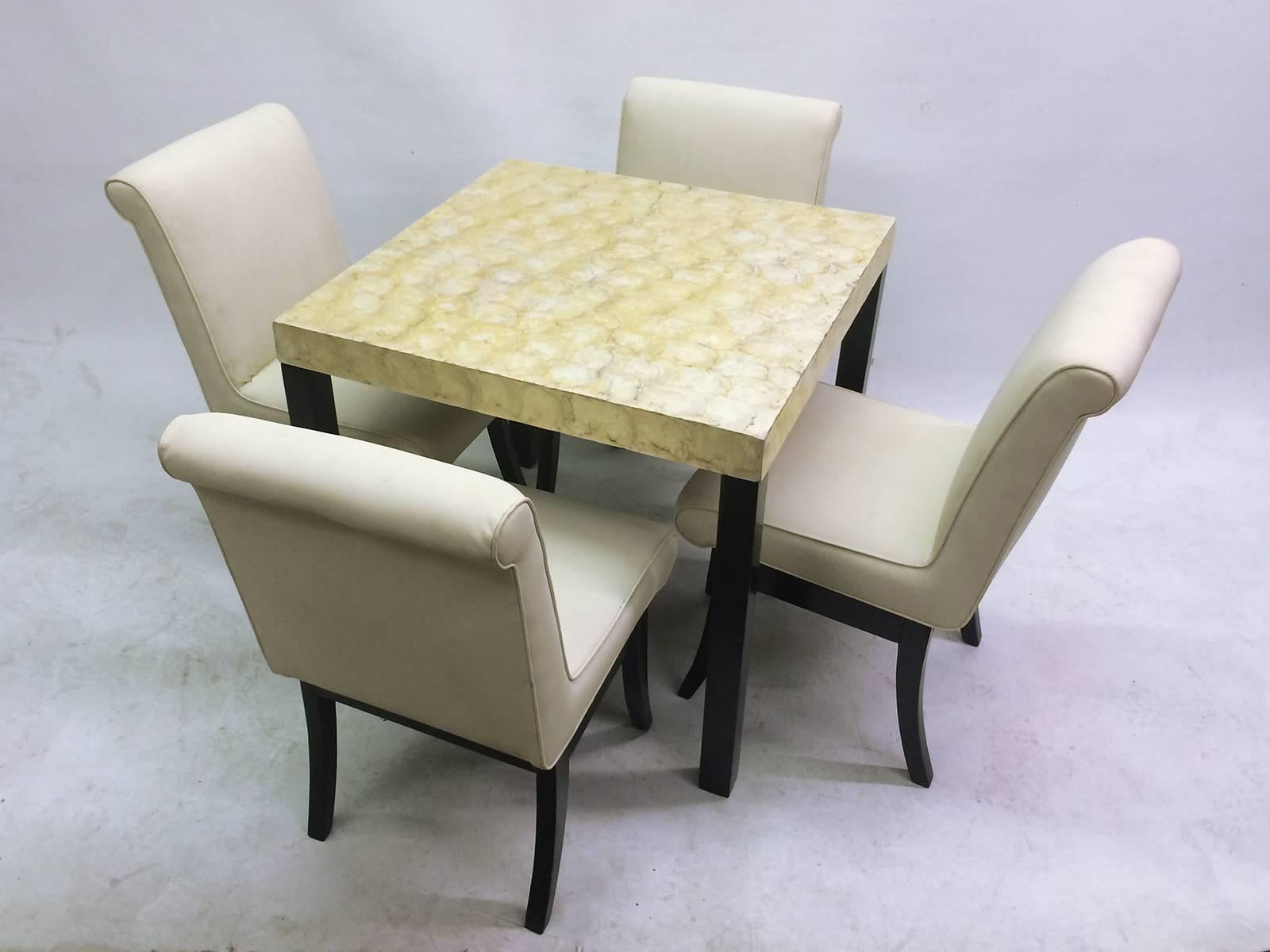 This is a five-piece dining set with an abalone surfaced table, original off-white Naugahyde chair coverings and black lacquer legs. Measurements below are for the chairs. Measures: The table is 32