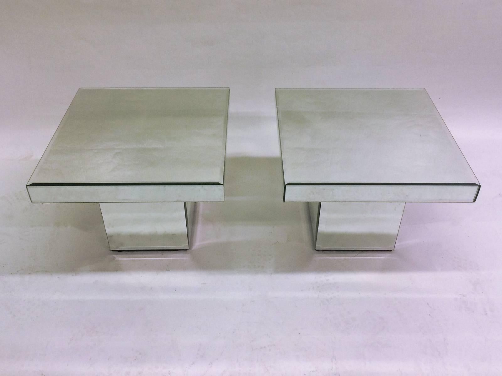 Two Mirrored end tables with square tops and square pedestal base.     