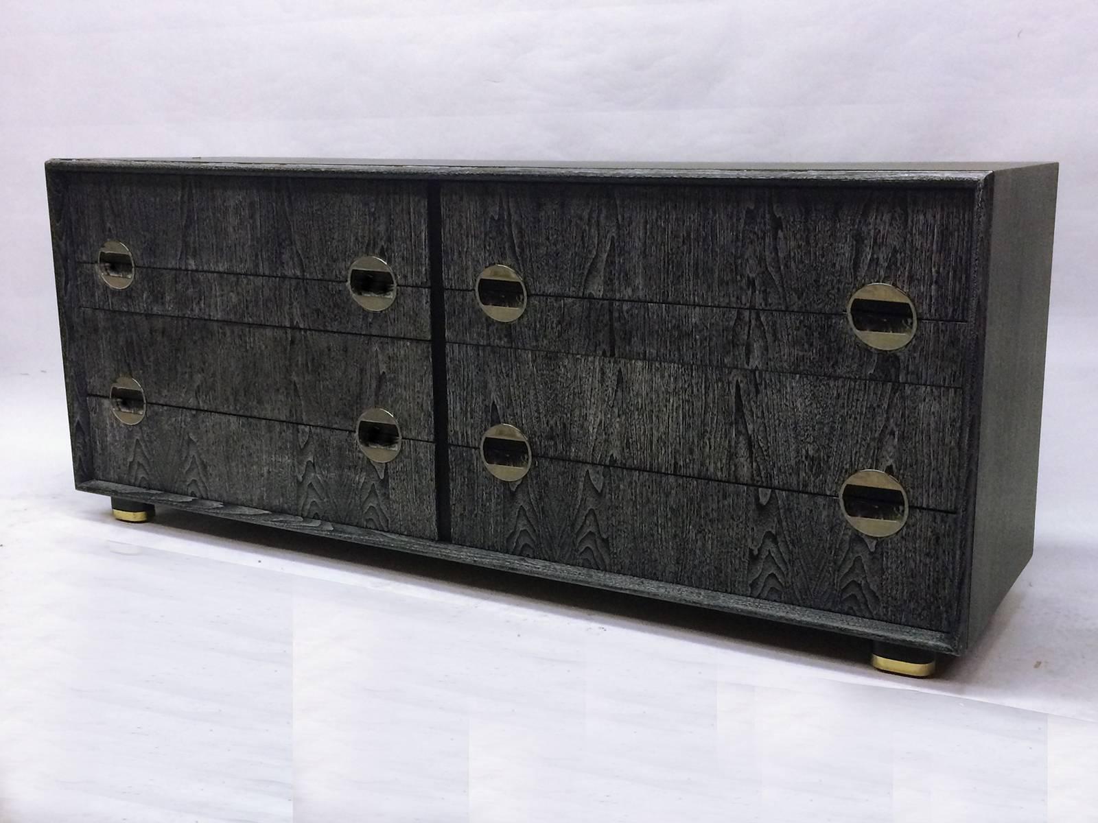 This is a cerused chest of drawers by Johnson furniture. Chest has original labels and features unique chromed handles, nine drawers and four brass capped legs.