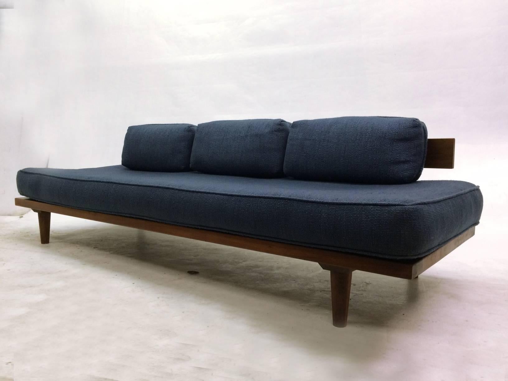 This Mid-Century daybed is constructed with a solid teak frame and round turned legs. The teak backrest is supported by welded steel brackets. The cushions are finished in a navy woven fabric.
It is very comfortable.