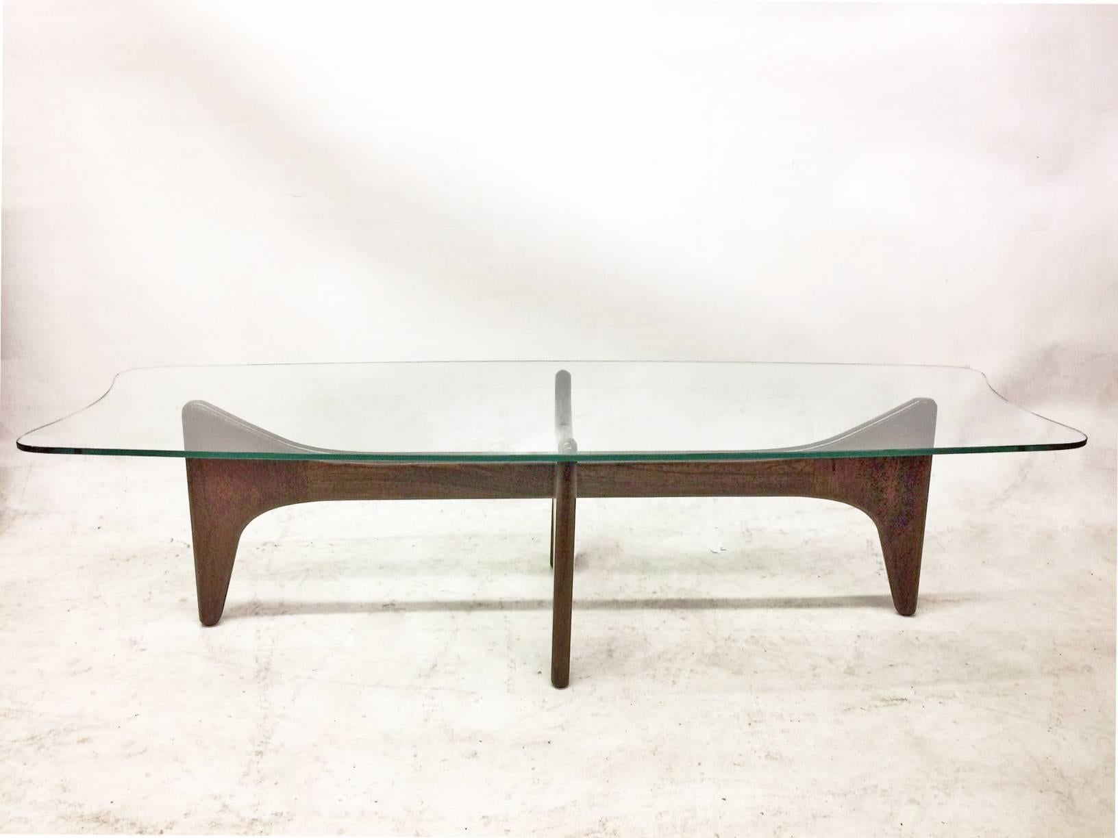 This cocktail table by Adrian Pearsall was manufactured by Craft Associates. The organically shaped walnut based is topped in glass.