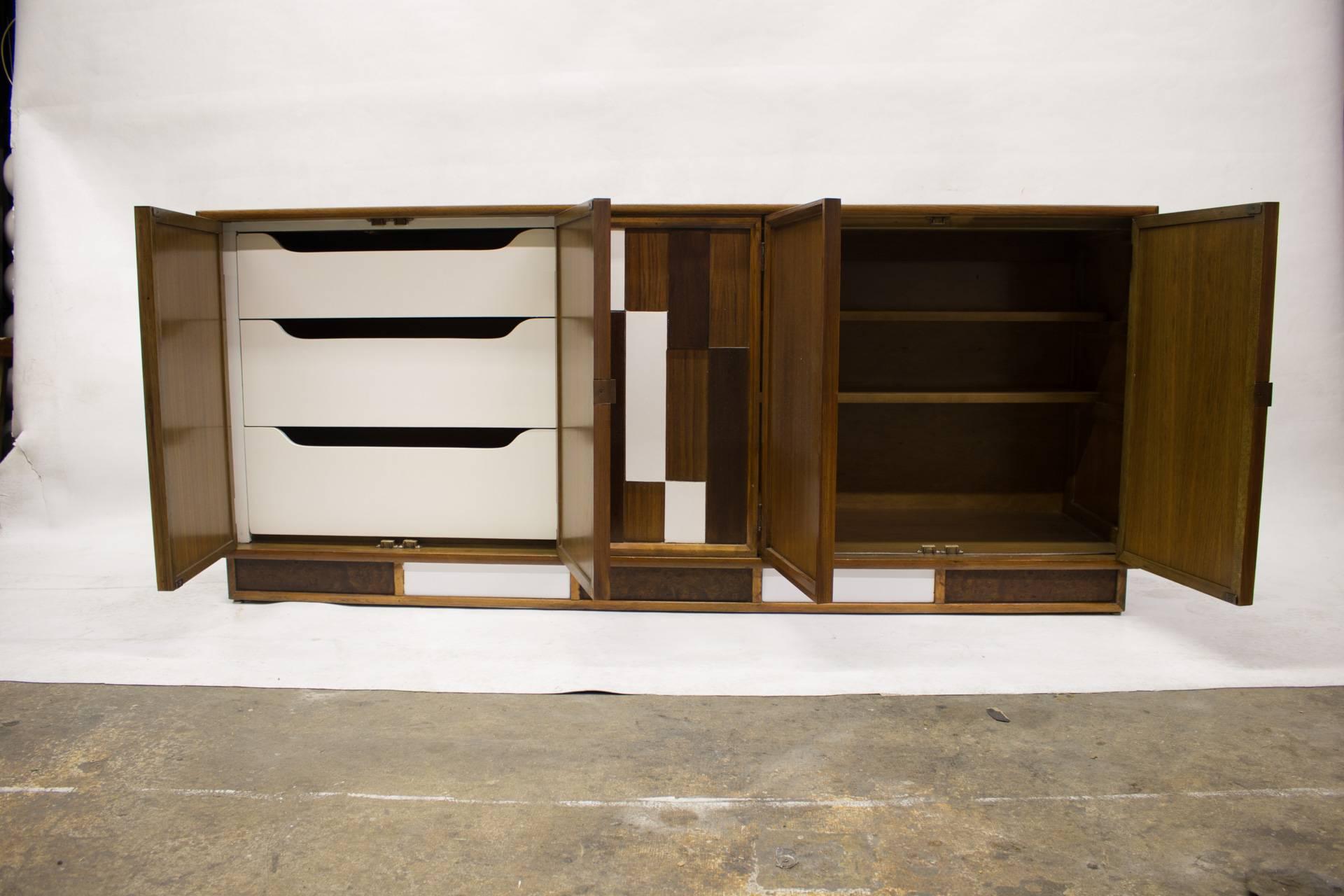 This cabinet combines graphic imagery and texture to capture a unique design. The two left doors open on three drawers and the two right ones on two half way shelves.
