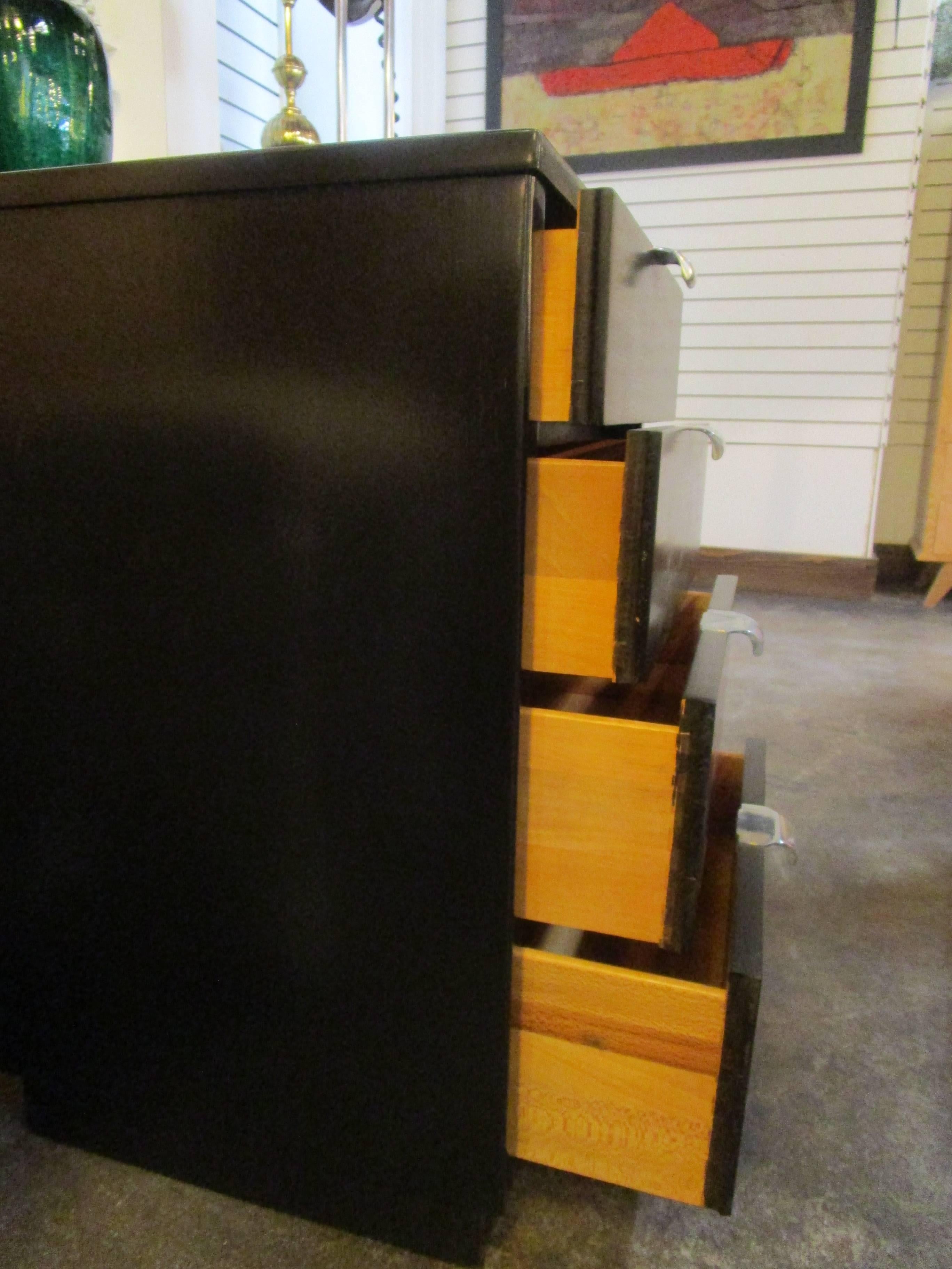 This mid-century nightstand of black stained walnut features steel drawer pulls and drawers in graduating sizes. The largest drawer, at the bottom, measures 7.50 inches high and the smallest on top is 5.0 inches. Marked by Drexel.
It was designed by