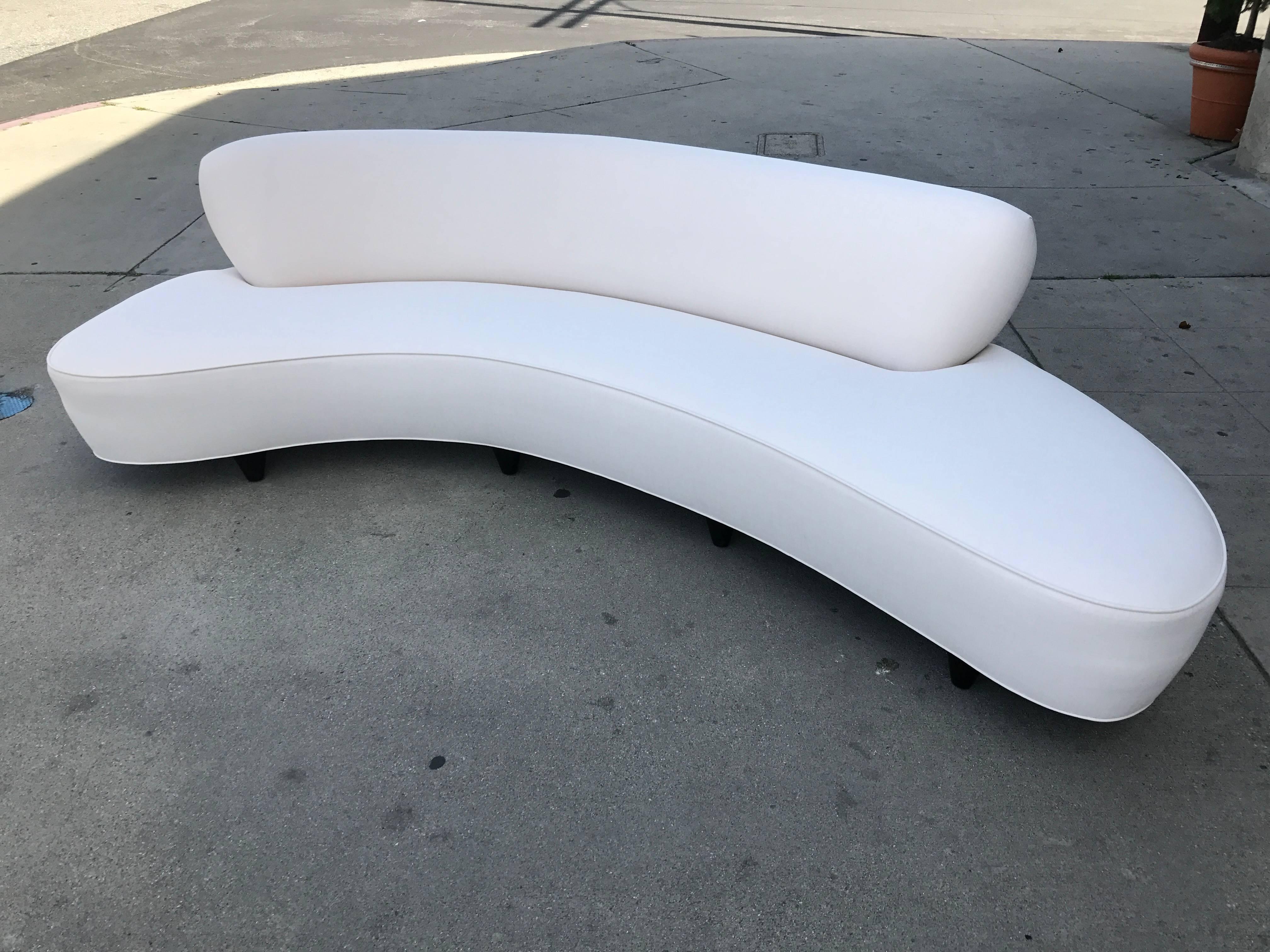 This sofa designed by Vladimir Kagan has been made in the 1990s by Modernica.
It has been reupholstered with a white canvas.
The legs are stained tapered wood. (see picture).

The total depth of the couch is 30.5" and the depth of just the