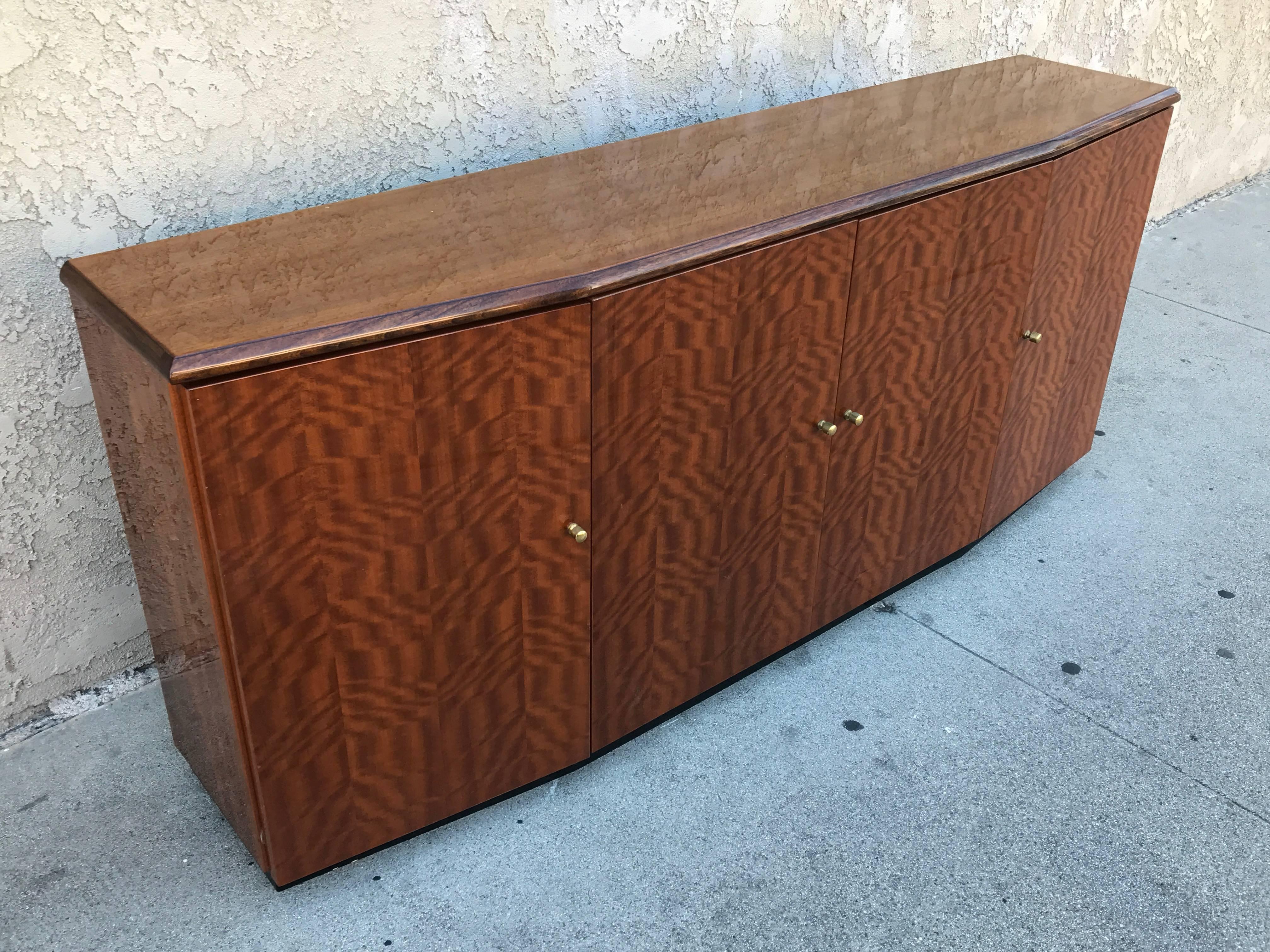 Four-door credenza made of the incredible koa wood which is from Hawaii and has its original polyurethane varnish which is in perfect shape! The knobs are in brass.
The inside features a shelf on each side and in the middle a drawer and a