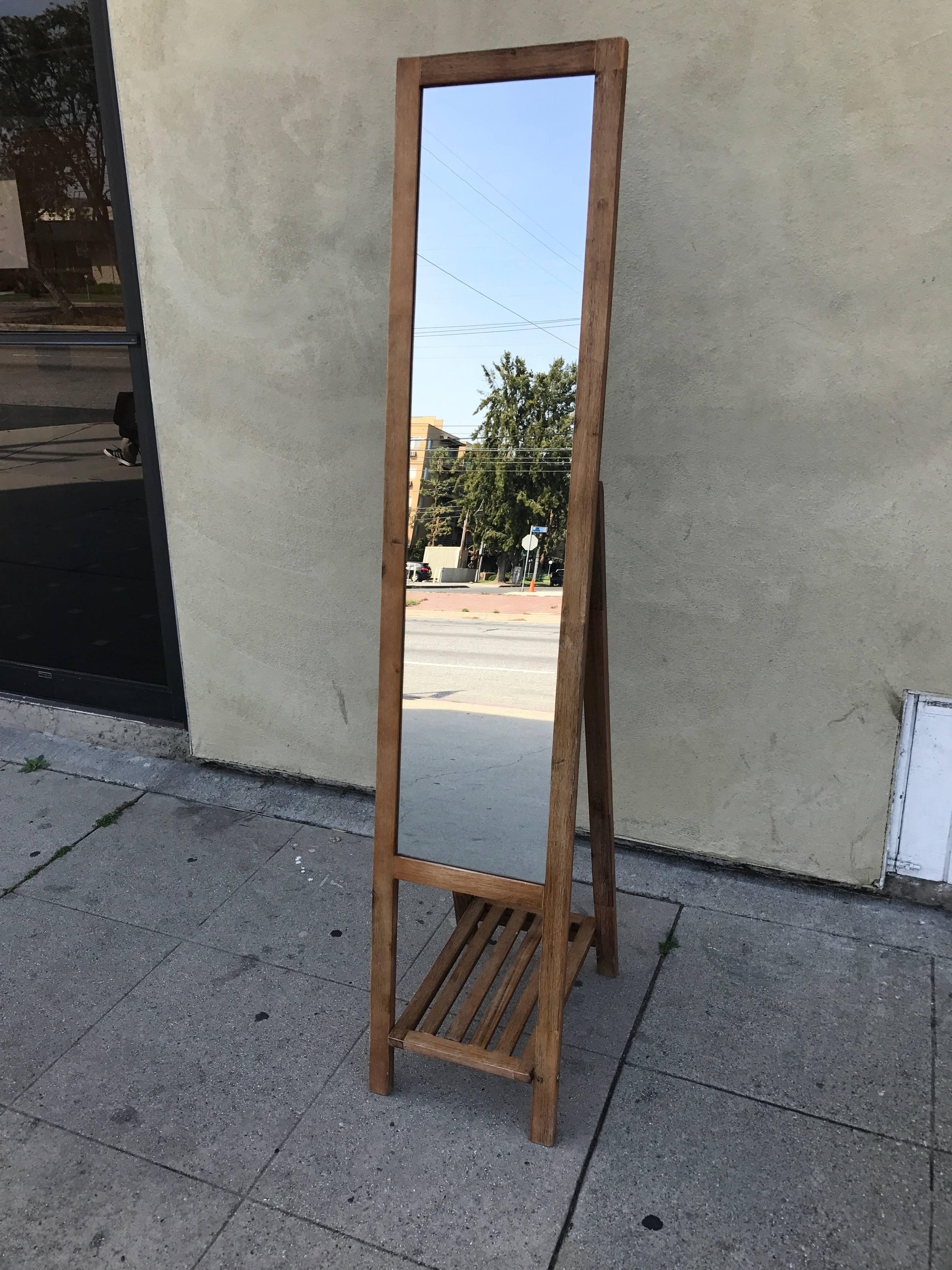 Standing oak mirror with slatted bottom shelf. Looks like an easel style and it is fordable.