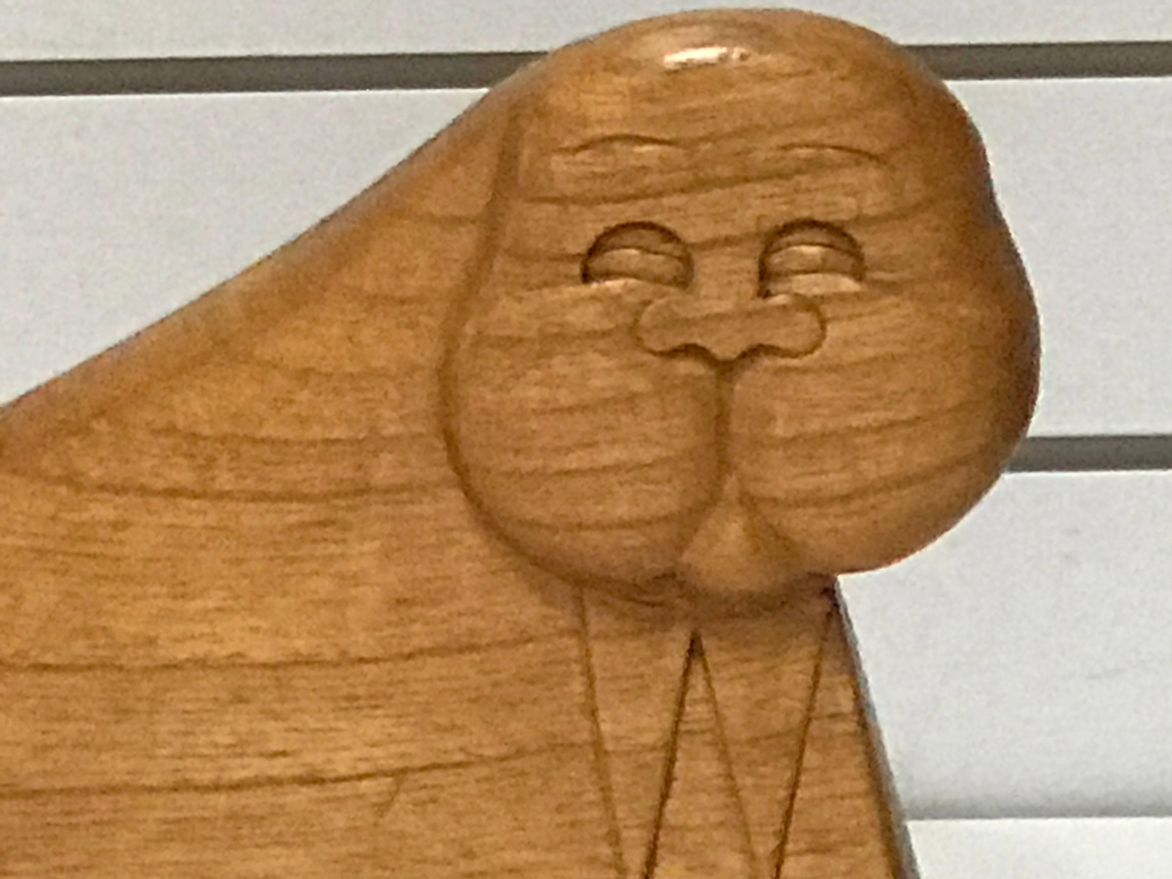 Very minimal yet very expressive sculpture of a walrus carved in a chunk of wood.