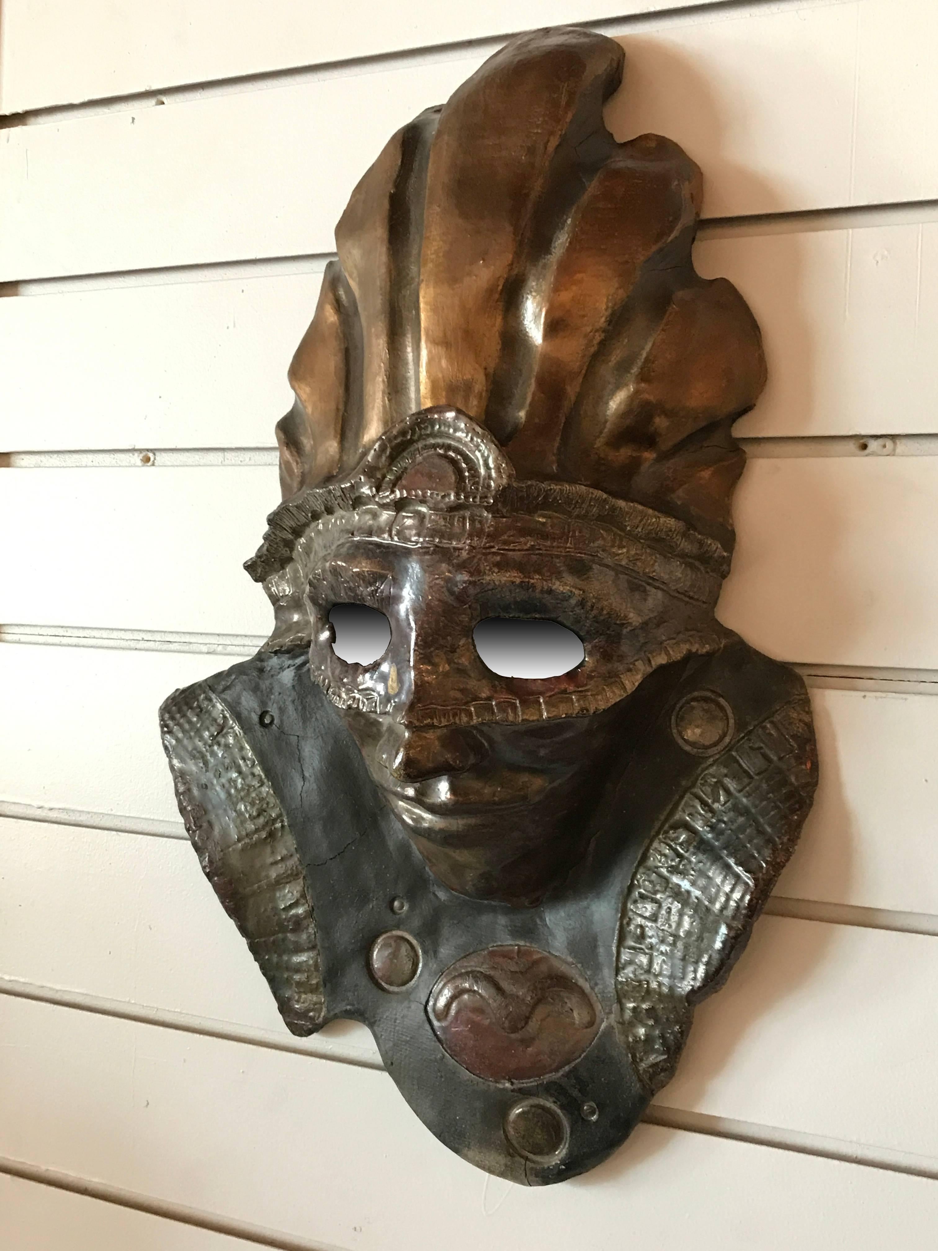 Raku style ceramic mask wall art of a warrior in a headdress.

Rakuware is Japanese hand-modeled pottery that is fired at a low temperature and rapidly cooled and typically used to make tea bowls. The technique became popular among American