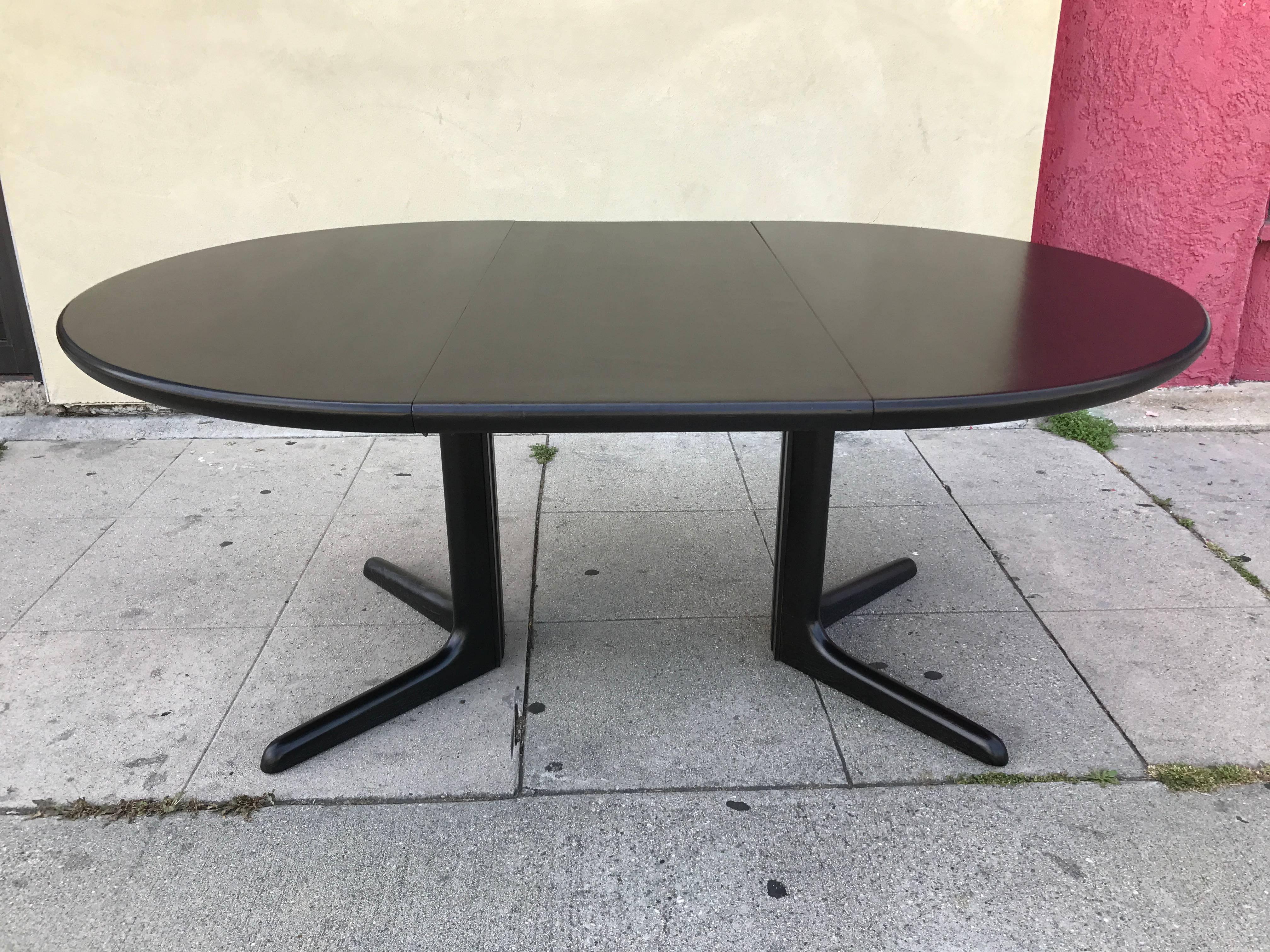 Round ebonized teak dining table comes with an extension which makes the table oval shaped. Design by Niels Koefoed for Koefoed

Extension measurements 19.63"
Total width of table with extension is 67.13".