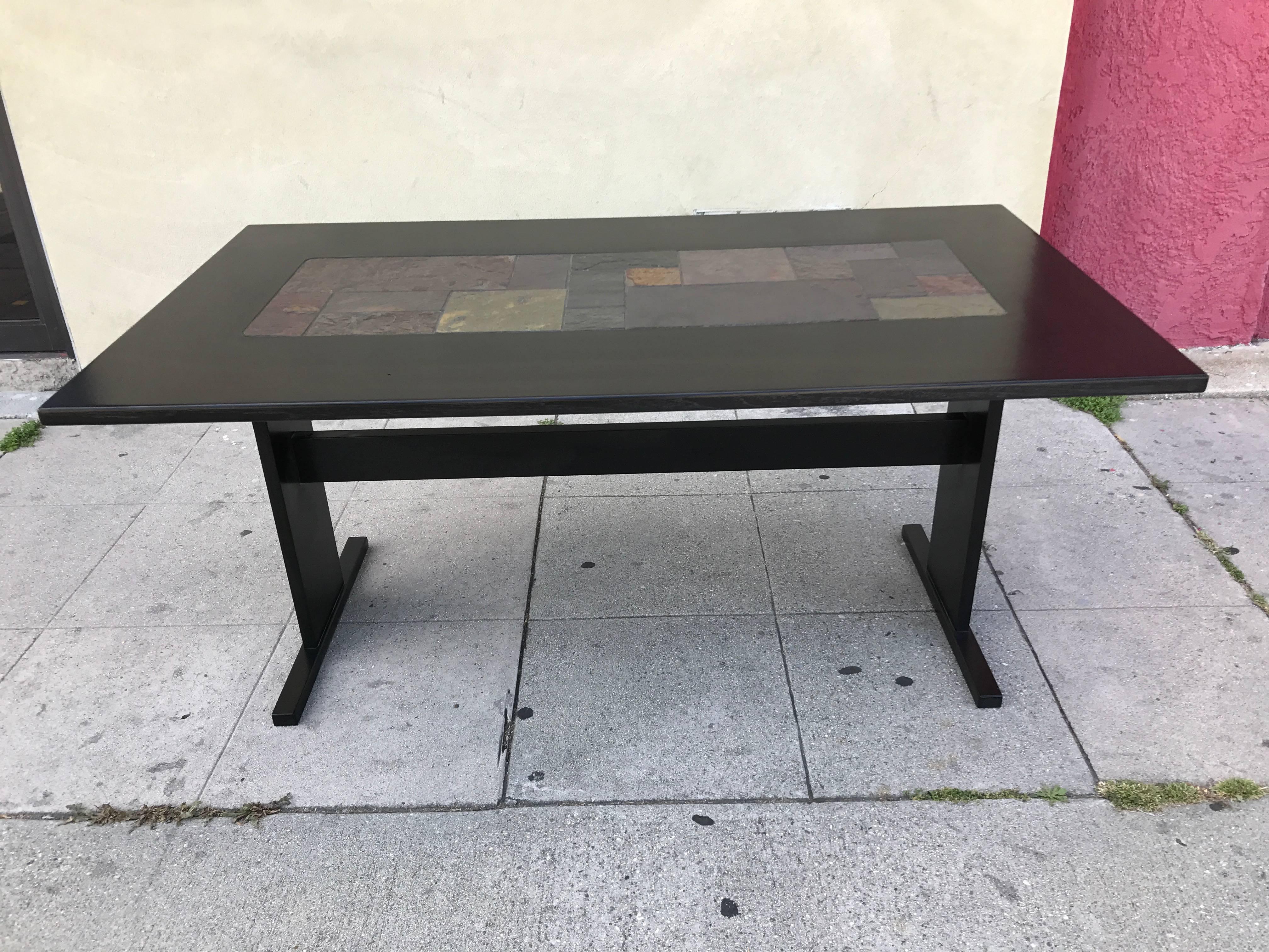 This black lacquered rectangular teak table has slate tiles inset into the middle and comes with an extension for each end. Please see photos for more details.

Width of table without the sleeves is 63.24