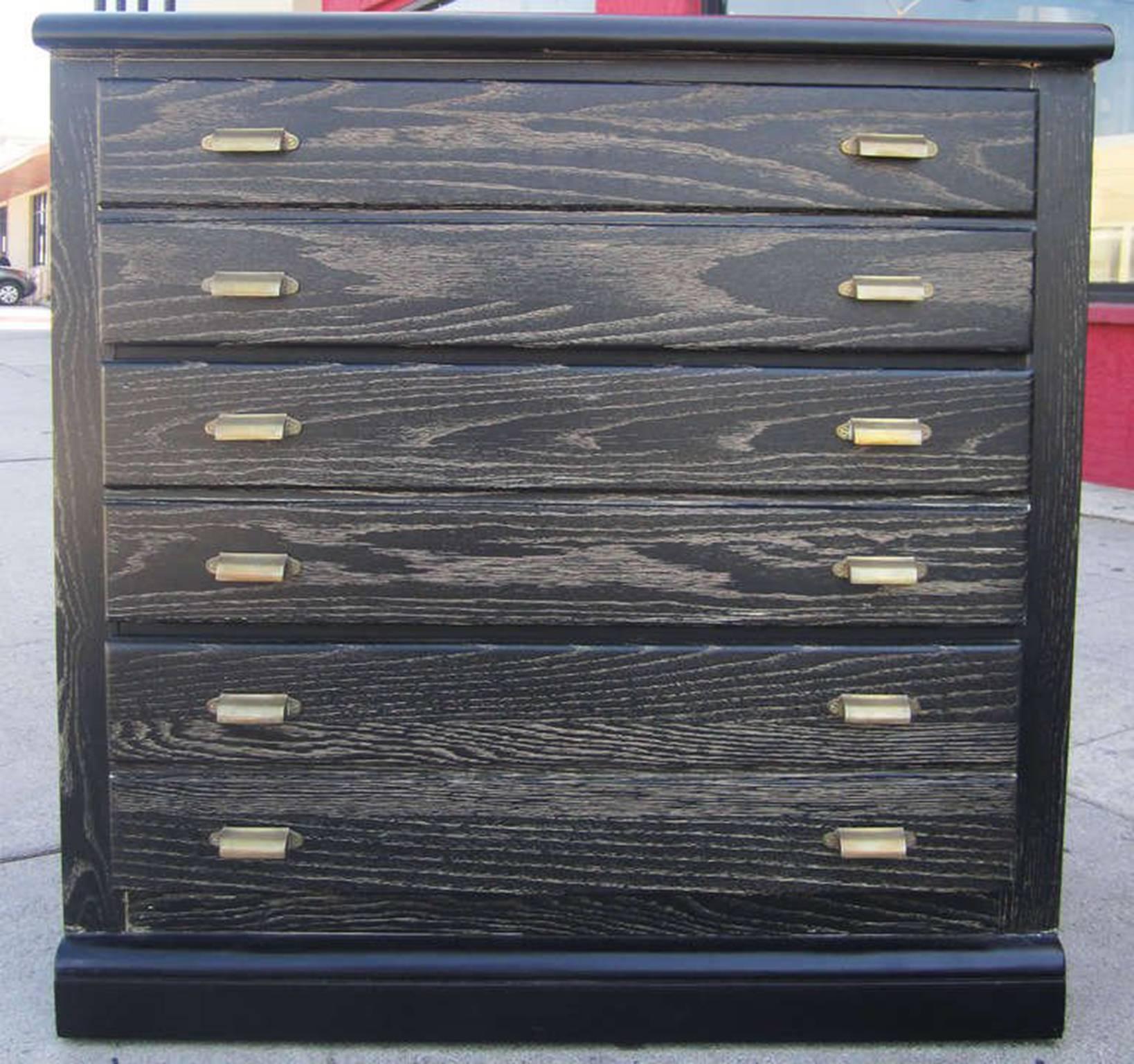 This cerused oak chest of drawers features Classic lines including a cornice and base which protrude slightly from the body of the piece. Because of the twelve scooped brass drawer pulls, the dresser appears to have six narrow drawers, instead every