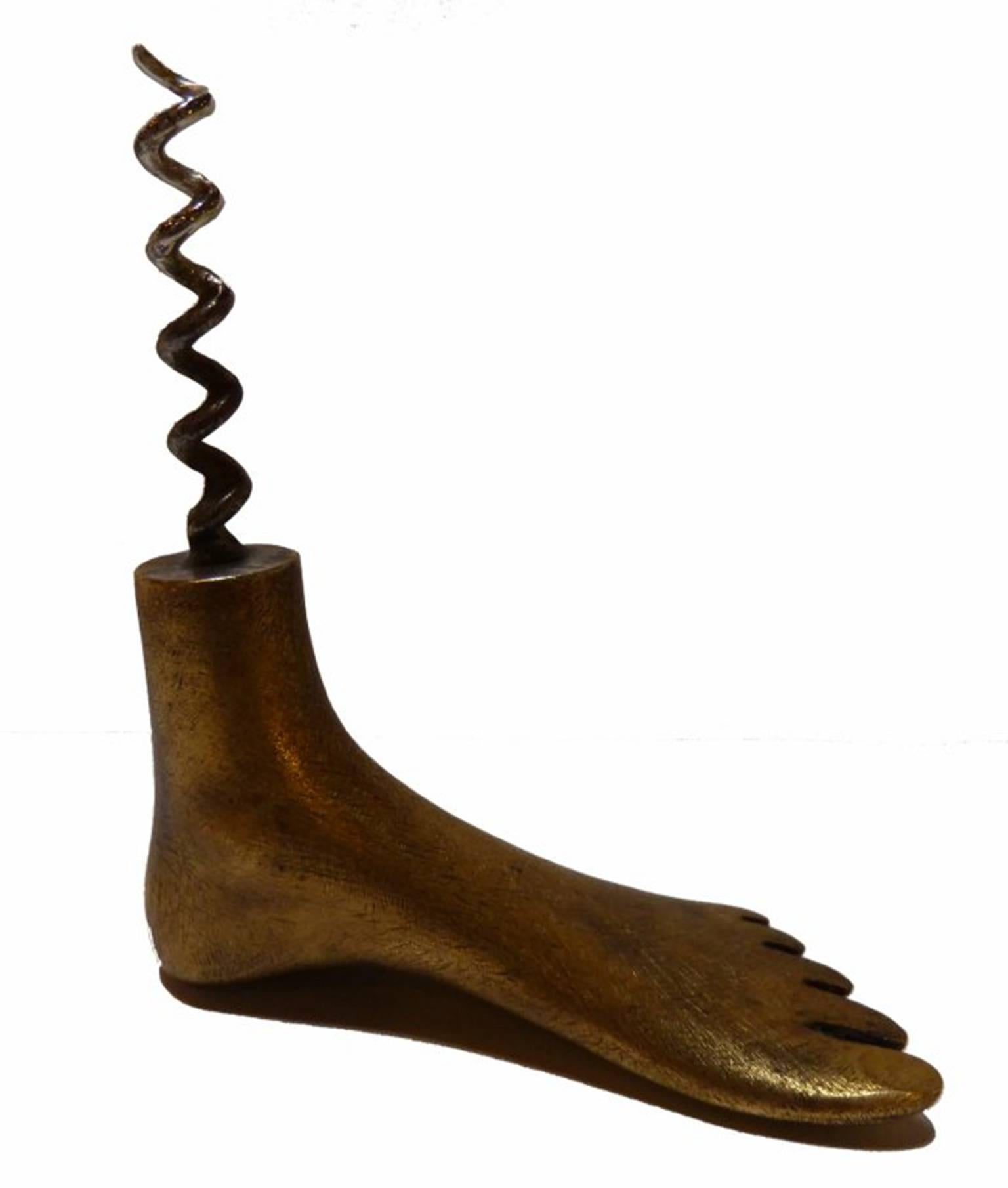 This Mid-Century Modern corkscrew in the shape of a foot was handmade in solid cast brass by the masterful Viennese designer Carl Auböck (1900-57). 
It is stamped on the sole of the foot with Auböck's last name as well as "Made in