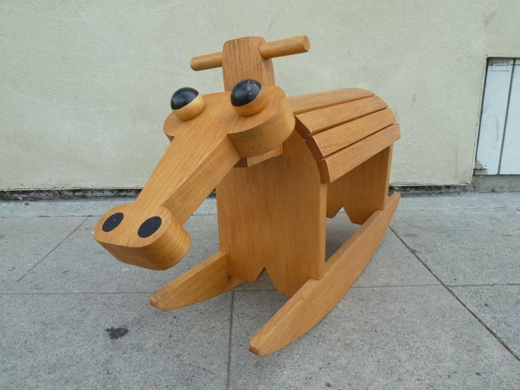 The conventional rocking horse has been reimagined in this striking, stylized form. The piece features large bulbous eyes and a wide flaring nose. On the side is written "Harrison".