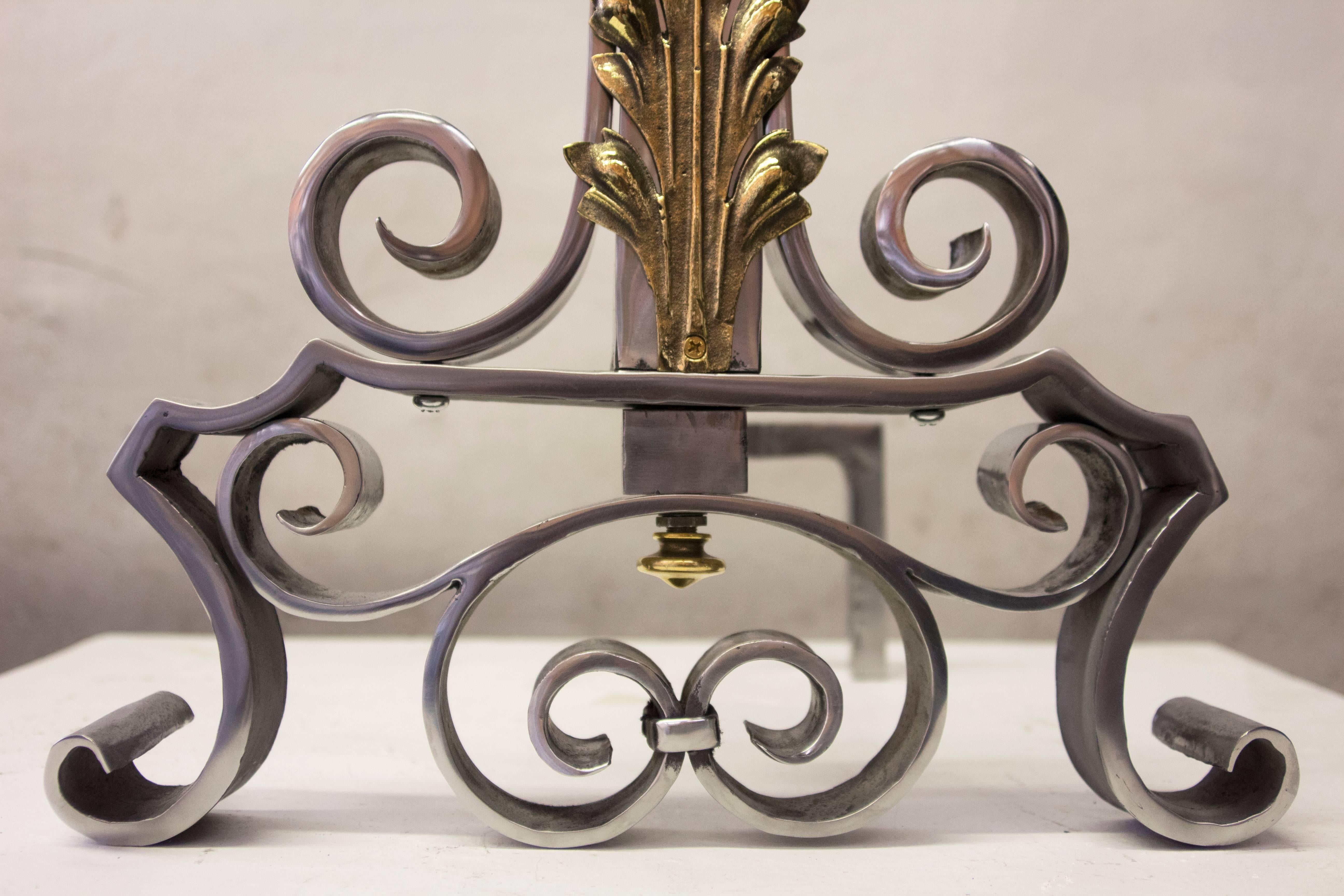 Very high end hand-forged wrought iron pair of andirons with bronze acanthus leaf and brass tassel as a finial.
They have been polished but you can see the traces of the hand work.