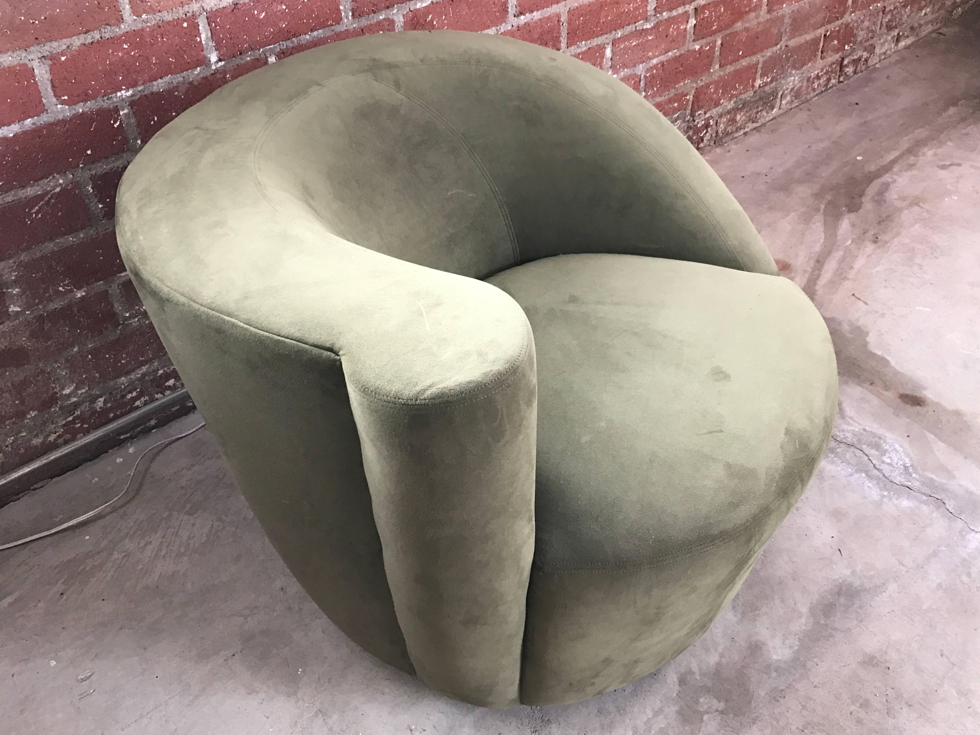 This pair of Classic Nautilus chairs designed by Vladimir Kagan for Directional feature a sloping, asymmetrical backrests and are upholstered in olive green. The chairs rest on swivel bases on a return which allow them to rotate 180 degrees and then