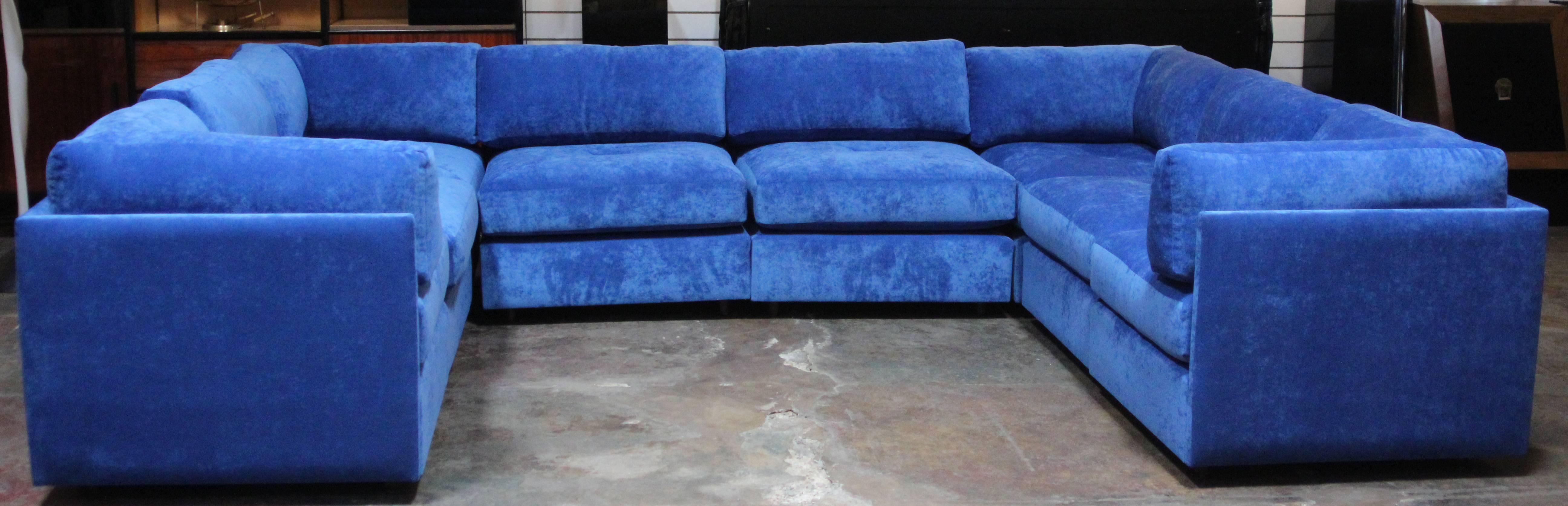 This sectional features four corner pieces, four slipper chairs and two storage ottomans.
They have been reupholstered in blue chenille.
All pieces are interchangeable and can be displayed in several different layouts as shown in