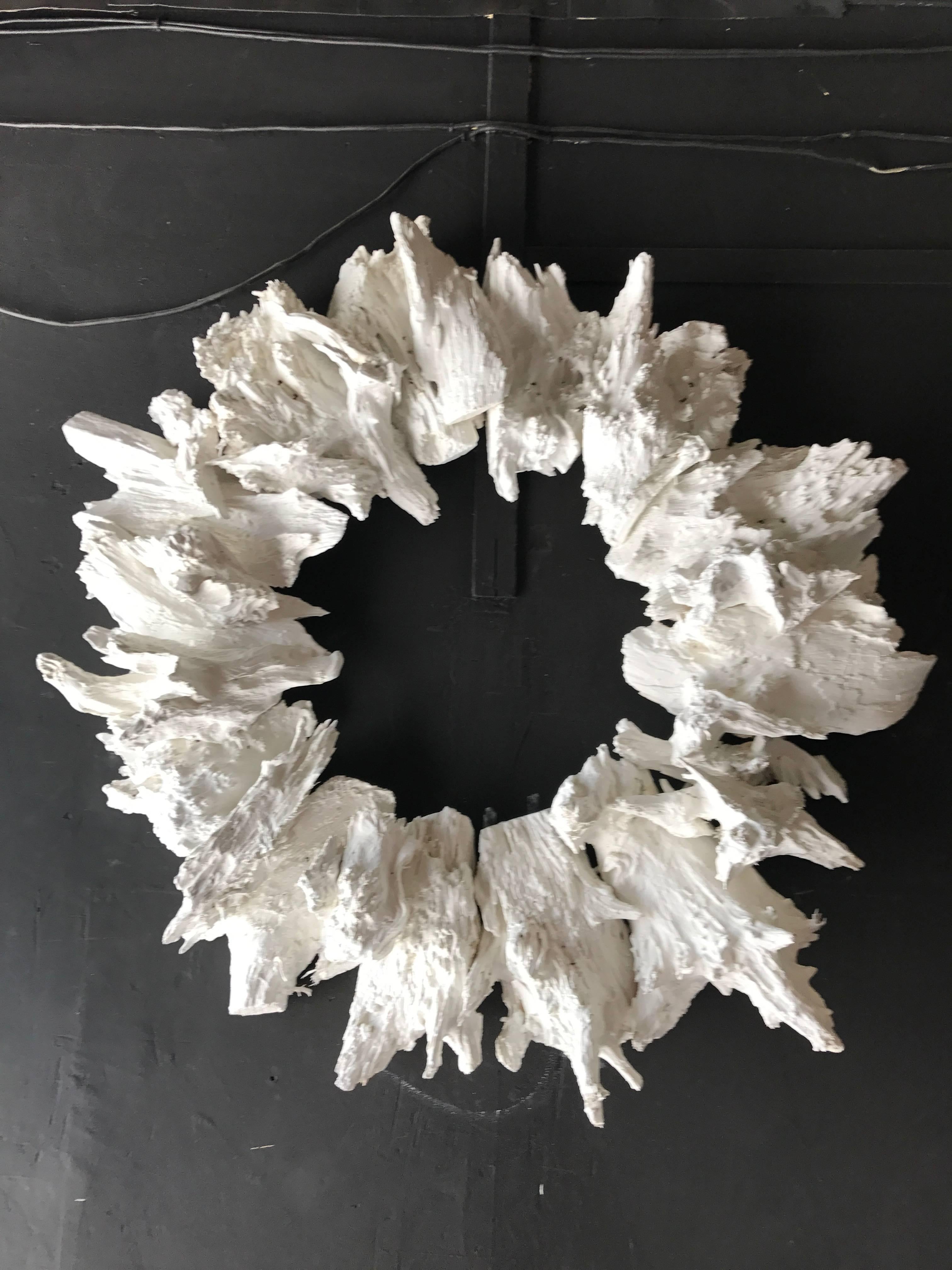 Sculptural crown made of white finished drift wood. May be used on its own as a piece of wall art, or as a frame for a mirror or other work of art. Due to the multi-layered texture of the piece measurements can vary throughout, but at its widest