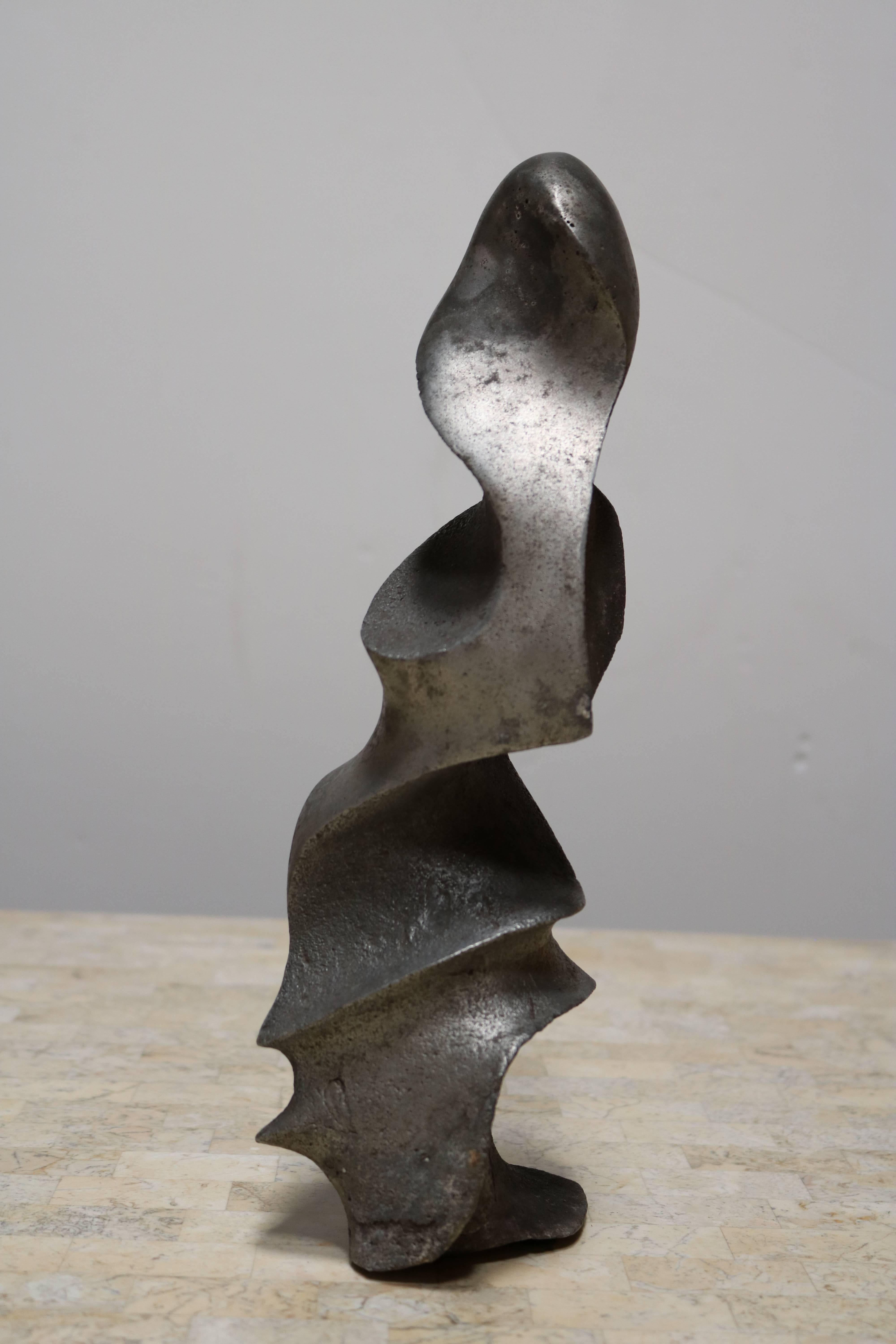 Interesting abstract sculpture which offers a very different interpretation following the way you look at it. It is made of lead.