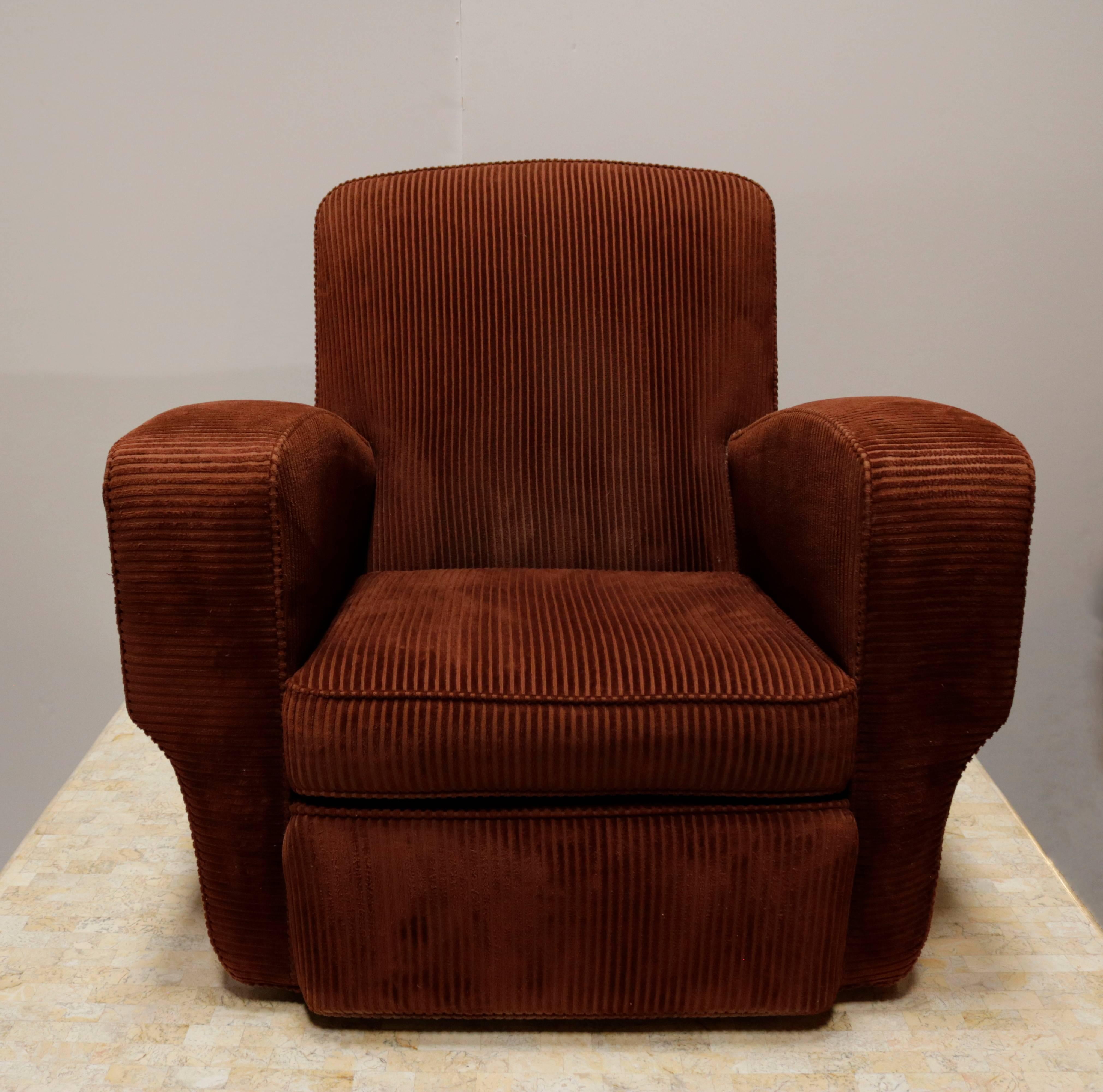 Pair of very comfortable French club chairs covered in their original rust colored corduroy. The seat is at a slight incline following the angle of the arms, the seat itself measures 19.0" wide. The chairs sit on wheels which have ordered at