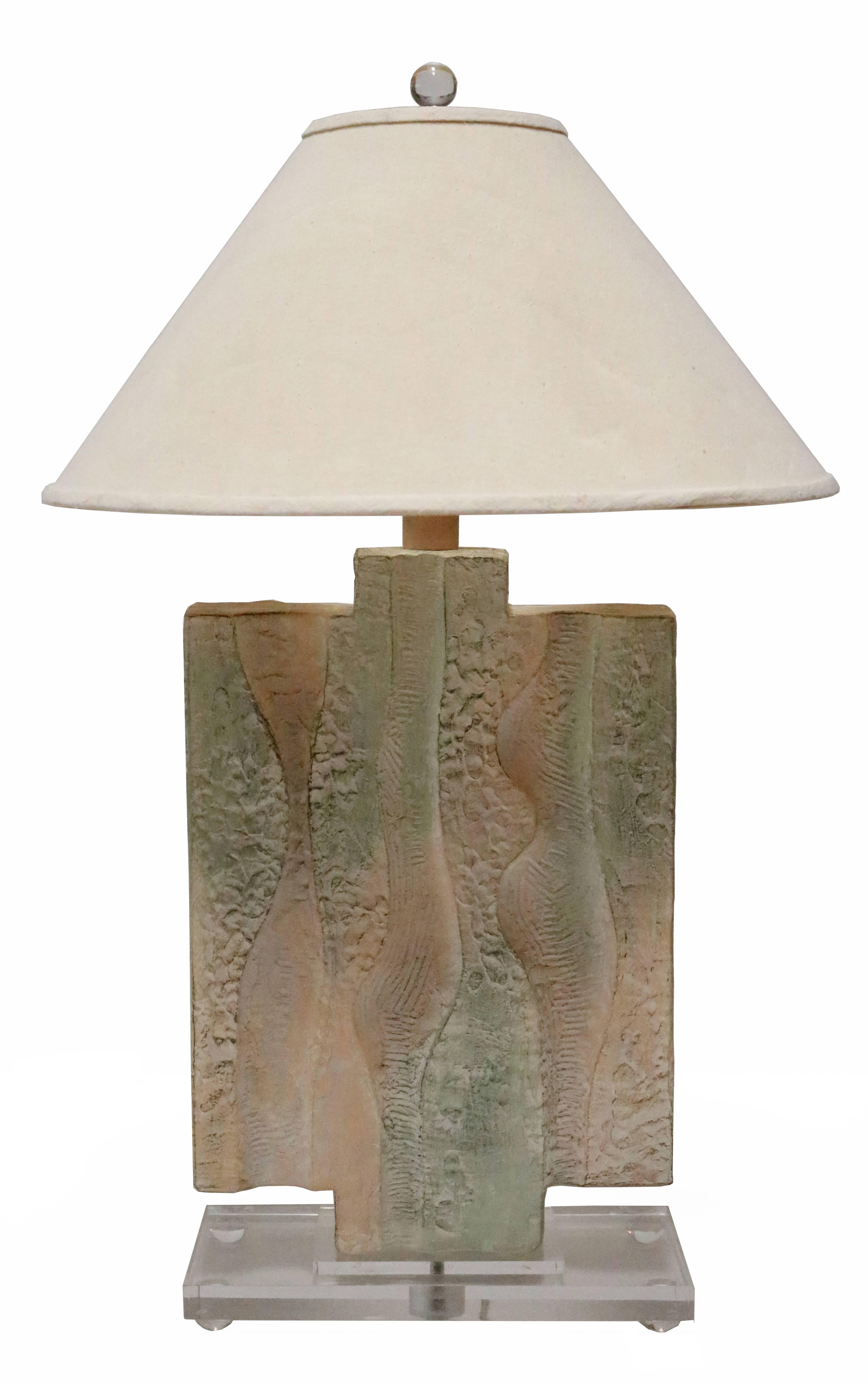 Pair of 1980s ceramic table lamps with an artful, textured finish and pastel tones. Each sits on a Lucite base
and has it's original canvas shade.
 