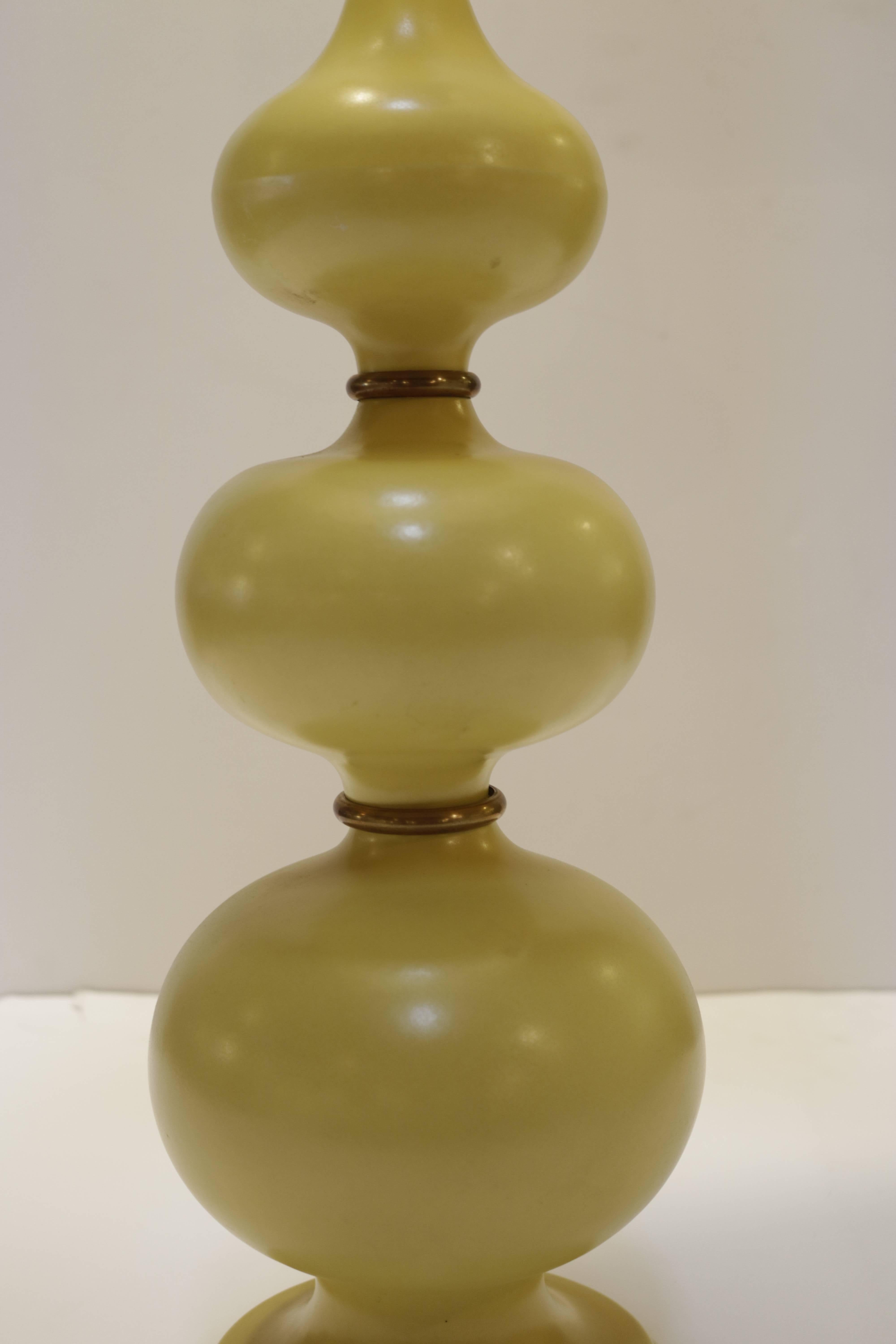 This 1950s atomic lamp is constructed with three porcelain bulbs and brass rings, fittings and original finial. Original beautiful warm yellow finish. Measures: Shade is 18.0 height x 16.0 inches diameter.