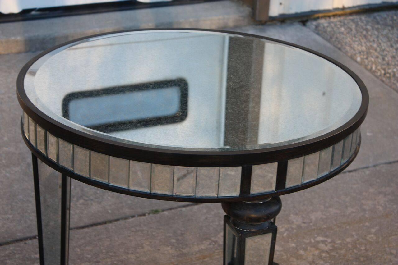 1980s mirror and ebonized wood tripped cocktail table. Striking take on a Classic traditional table design. Interesting carved bobbin feet and support. Legs are mirror paneled with beveled edges. Edges are mirror panel in a mosaic. Surface is thick