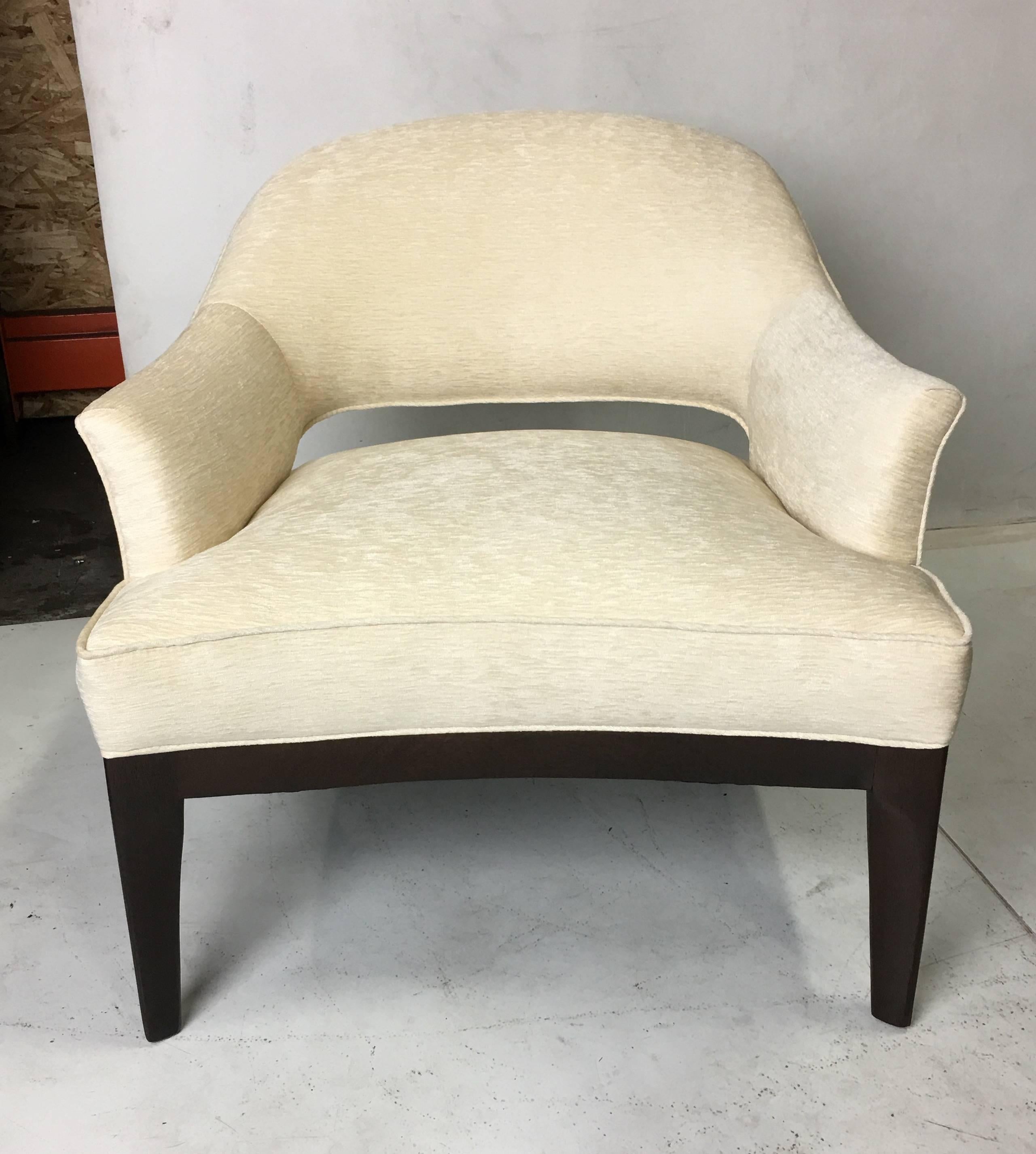 Pair of lounge chairs meticulously refinished in medium-dark walnut lacquer.  The fin shaped legs flow into the frame at an angle making a beautiful sculptural statement. These versatile chairs are super comfortable and handsome.  All work done with