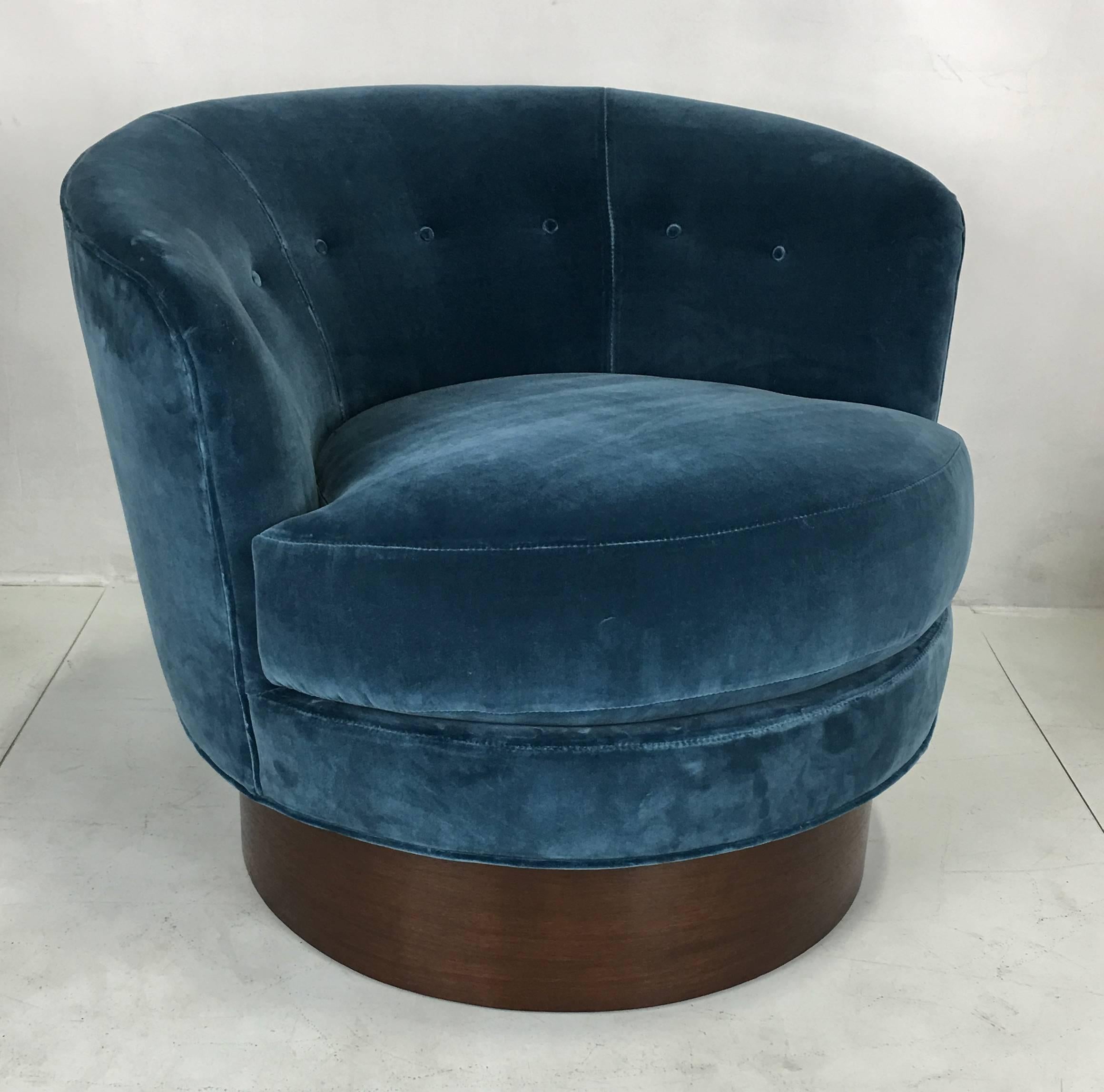 Chic pair of velvet barrel chairs raised on walnut swivel bases. Meticulous ground up restoration. Freshly reupholstered in luxurious heavyweight teal velvet.  All work done with painstaking quality at Antiques du Monde's in-house workroom.  