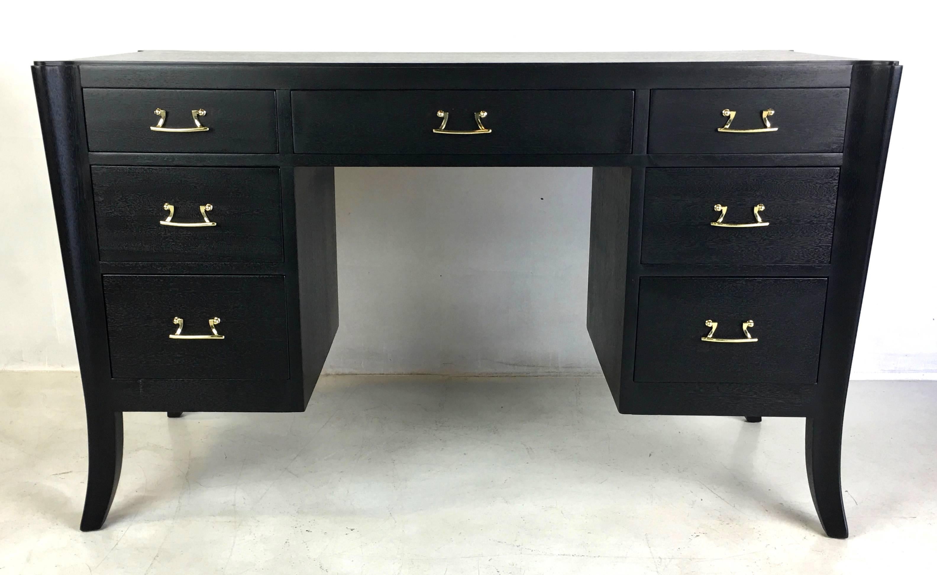 Very rare and early modernist ebonized mahogany desk with sculpted saber legs and stylized bail pulls by Paul T. Frankl for Brown-Saltman. The desk has been completely restored and refinished and the solid brass hardware has been freshly polished