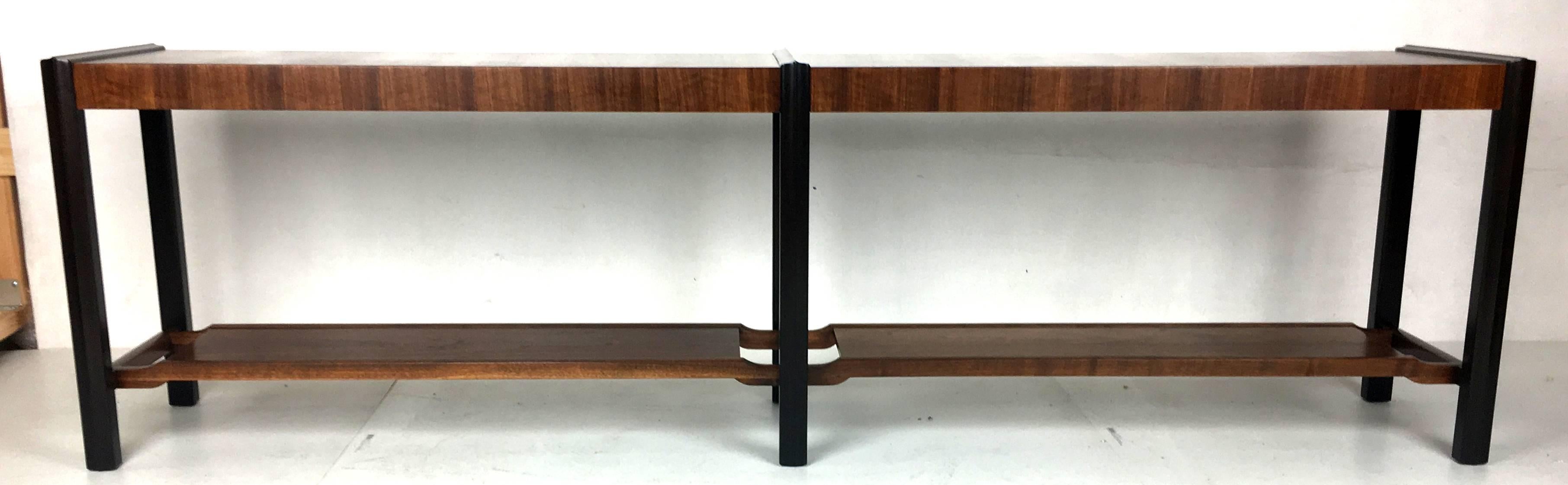 Beautifully crafted long and low console table with dark mahogany supports and rosewood veneered shelves. The entire piece is finely detailed along with the offset bottom shelves. This is a first class piece of Modernist furniture in the style of