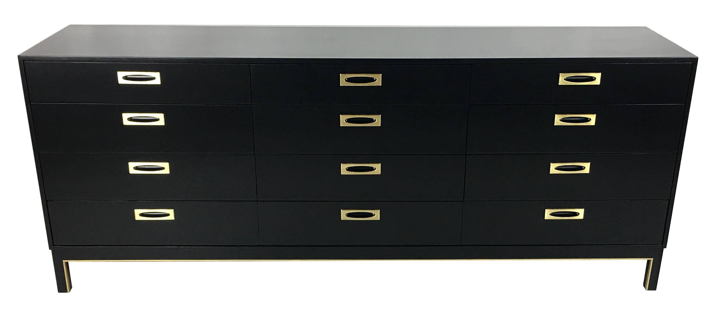 Thin-edge 12-drawer dresser with flush brass finger pulls and brass trimmed base. The dresser has been painstakingly refinished along with the brass mounts, which have been done in a light brushed finish and clear-lacquered. Finest quality materials