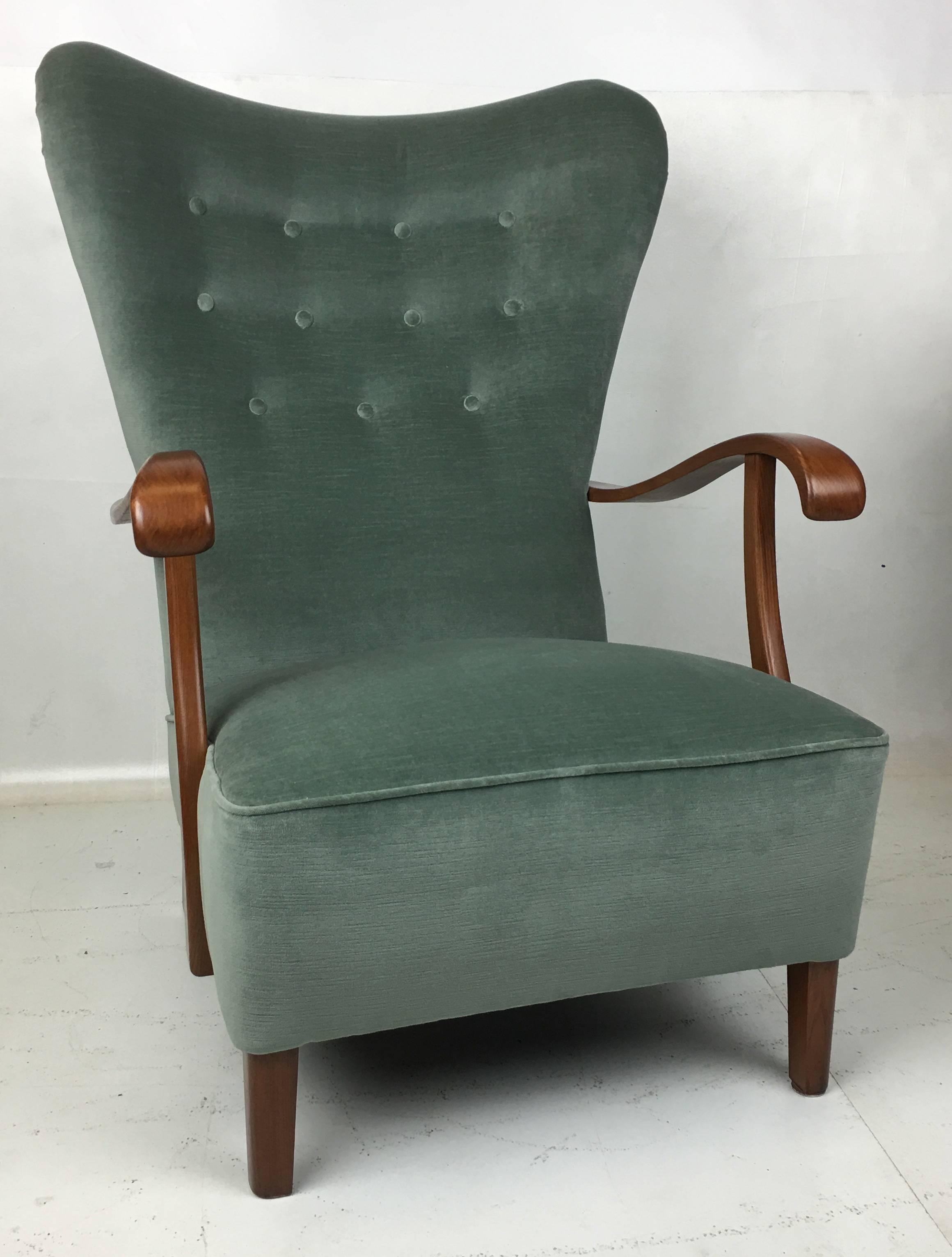 Handsome Wing chair with swooping arms and purposeful legs. The chair has been meticulously restored from the ground up; refinished, reglued, new webbing, 8-way hand tied springs, new foam and has been freshly reupholstered in luxurious heavyweight