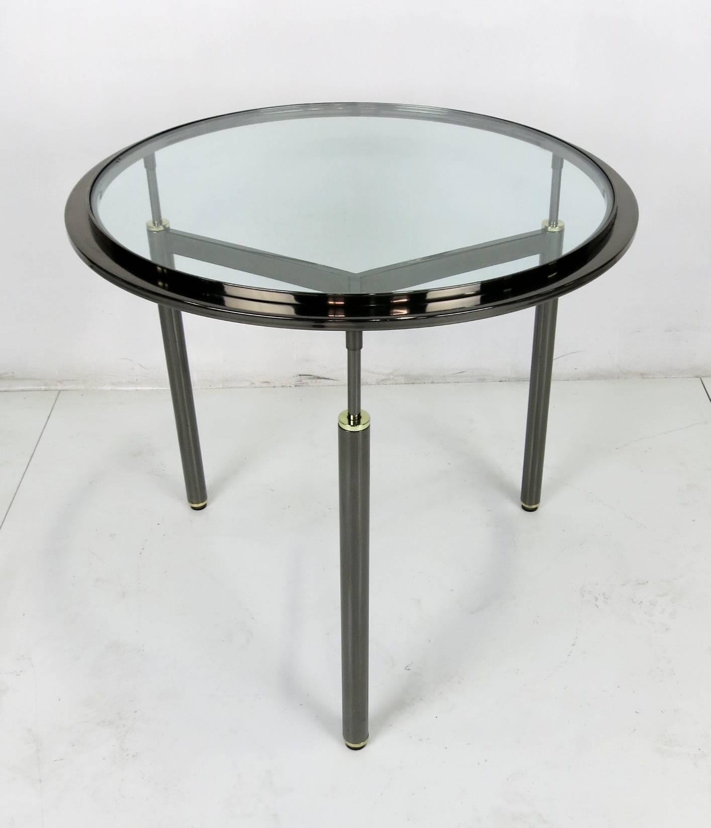 Handsome pair of gunmetal plated tripod tables with brass mounts in the style of John Saladino.
