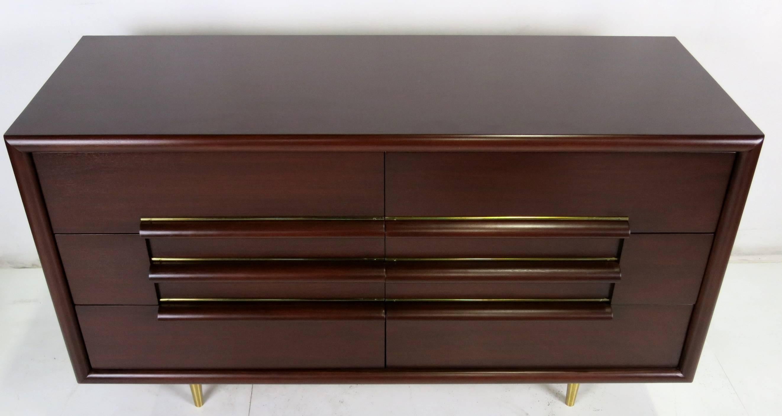 Handsome Mid-Century Modern dresser with brass-trimmed thick finger pulls and tapered brass legs meticulously restored and refinished in dark brown lacquer by Furniture Guild of California, circa 1950s. The brass legs have also been refinished and
