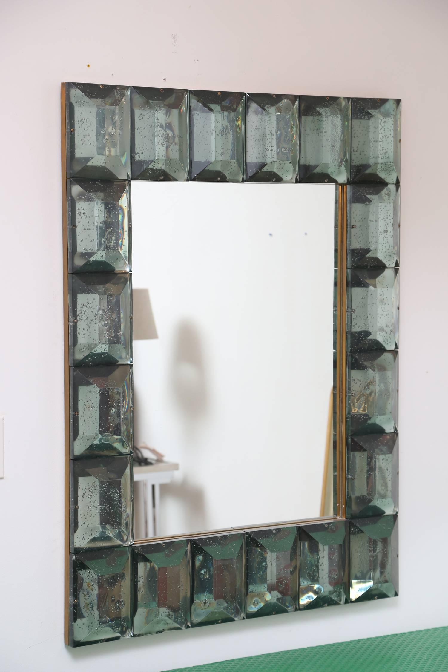 Modern Italian studio built Murano glass and brass frame mirror.
Each aqua green glass block has a highly polished diamond faceted cut pattern with air inclusions throughout. Can be displayed either horizontally or vertically.
Please inquire for