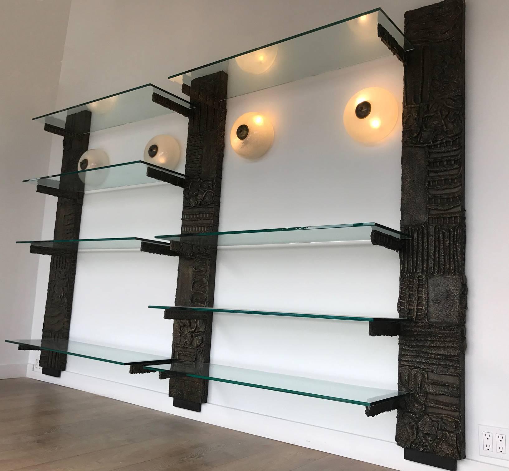 Paul Evans wall unit triple pilaster in brutalist sculpted bronze resin. Eight clear glass shelves.
Model PE 119
Signed and dated PE 69
Warmed patina to vertical.