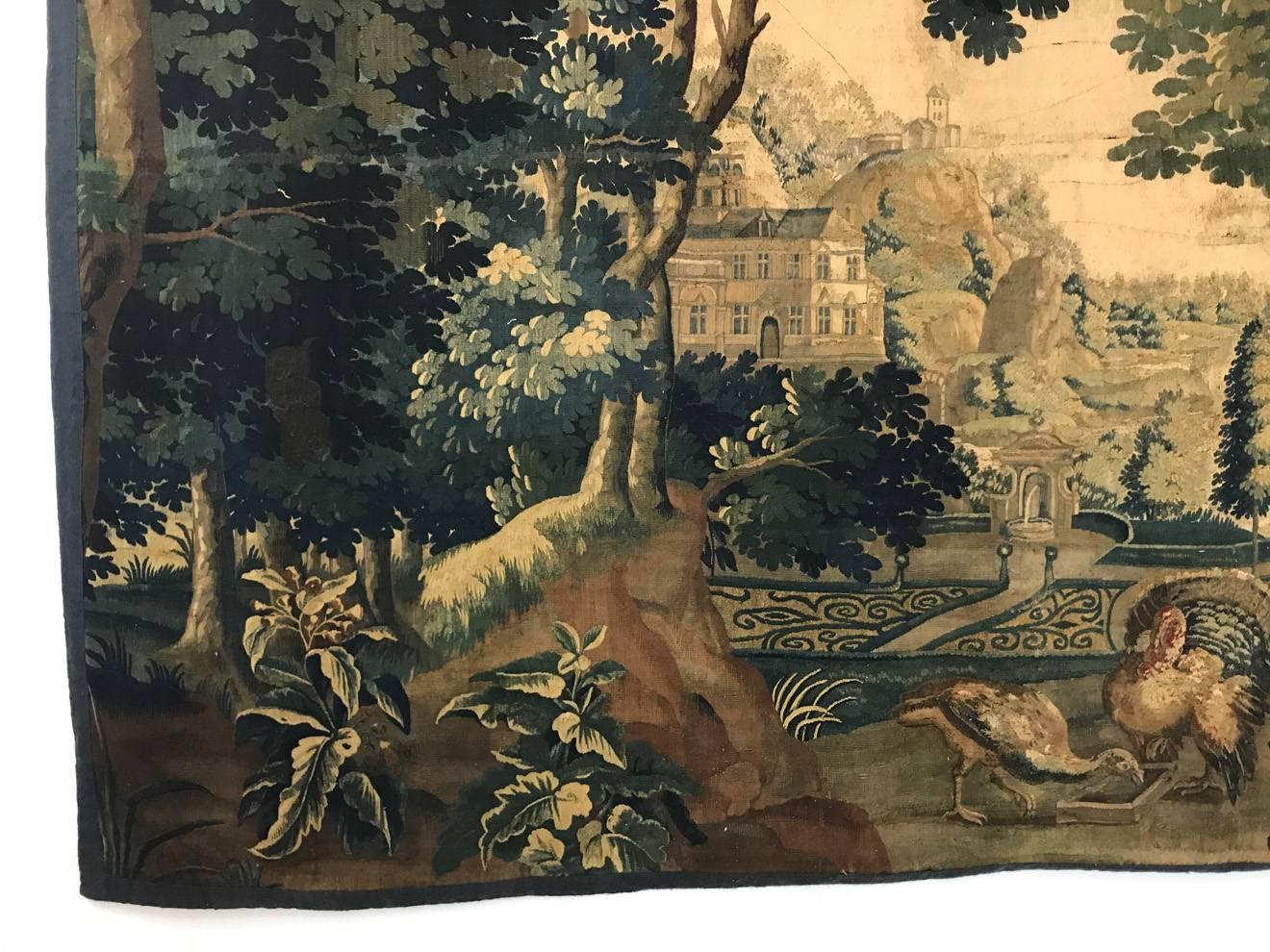 Oversize Flemish verdure tapestry 17TH/18TH CENTURY .   
Gorgeous flora and fauna scenery with a castle in the background.  Despite of the age, this piece has maintained its vivid colors.   
