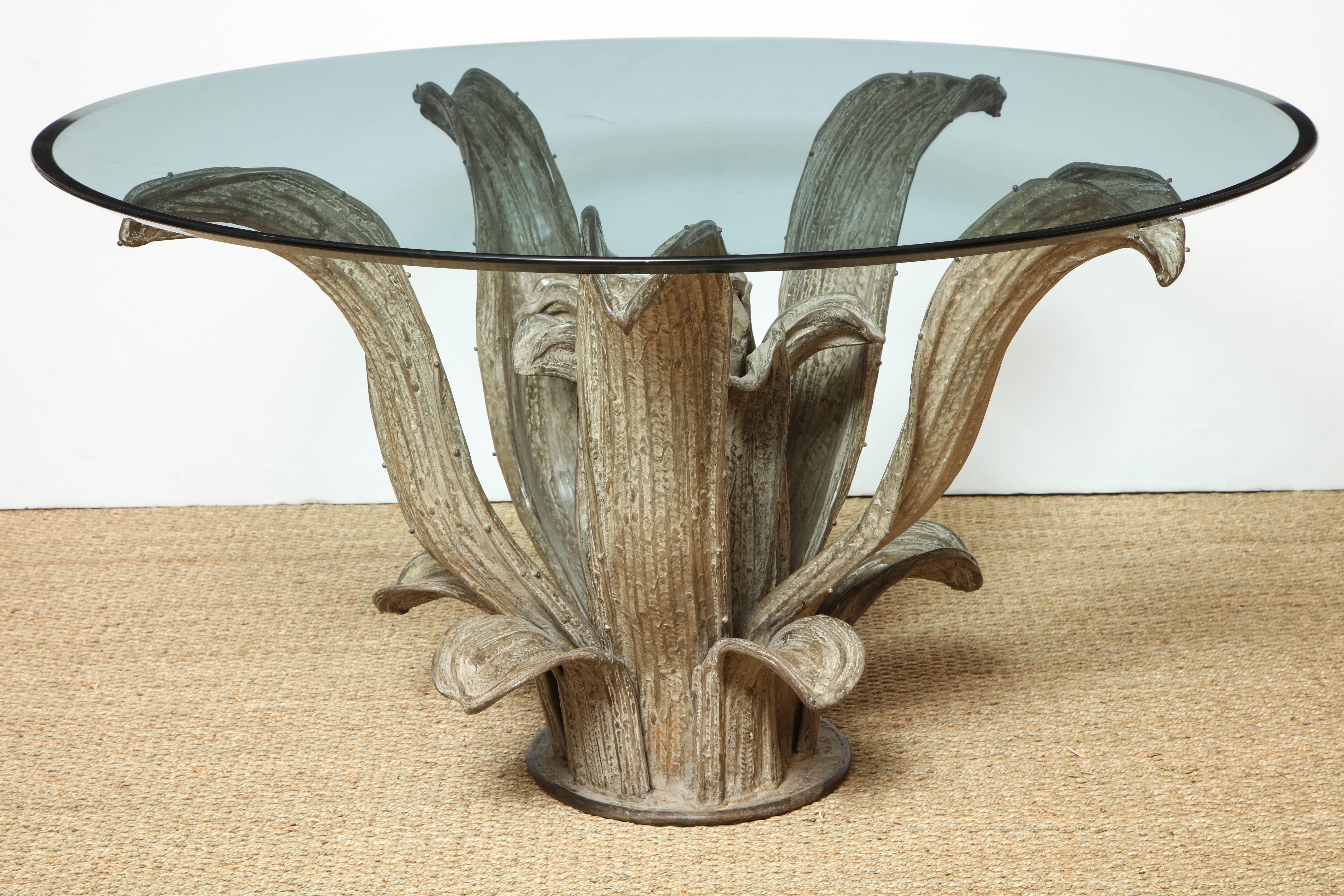 Sculptural center table base in the form of an agave cactus plant with a large circular glass top, (some scratches to glass). Base is flame worked and hammered brass with a natural patina. Excellent condition.
 Base measures 48