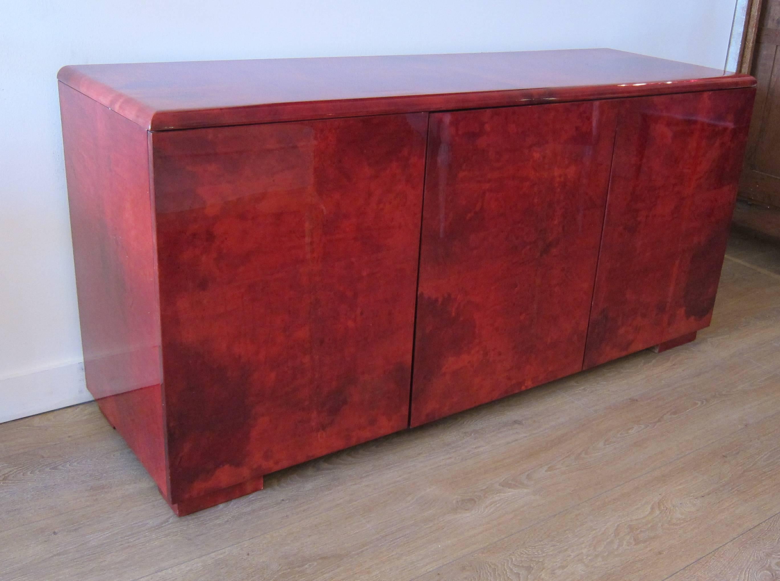 Rare vibrant red goatskin three doors cabinet by Aldo Tura, Italy, circa 1970s. Excellent vintage condition some light scratches on top. Vibrant and rich red goatskin.